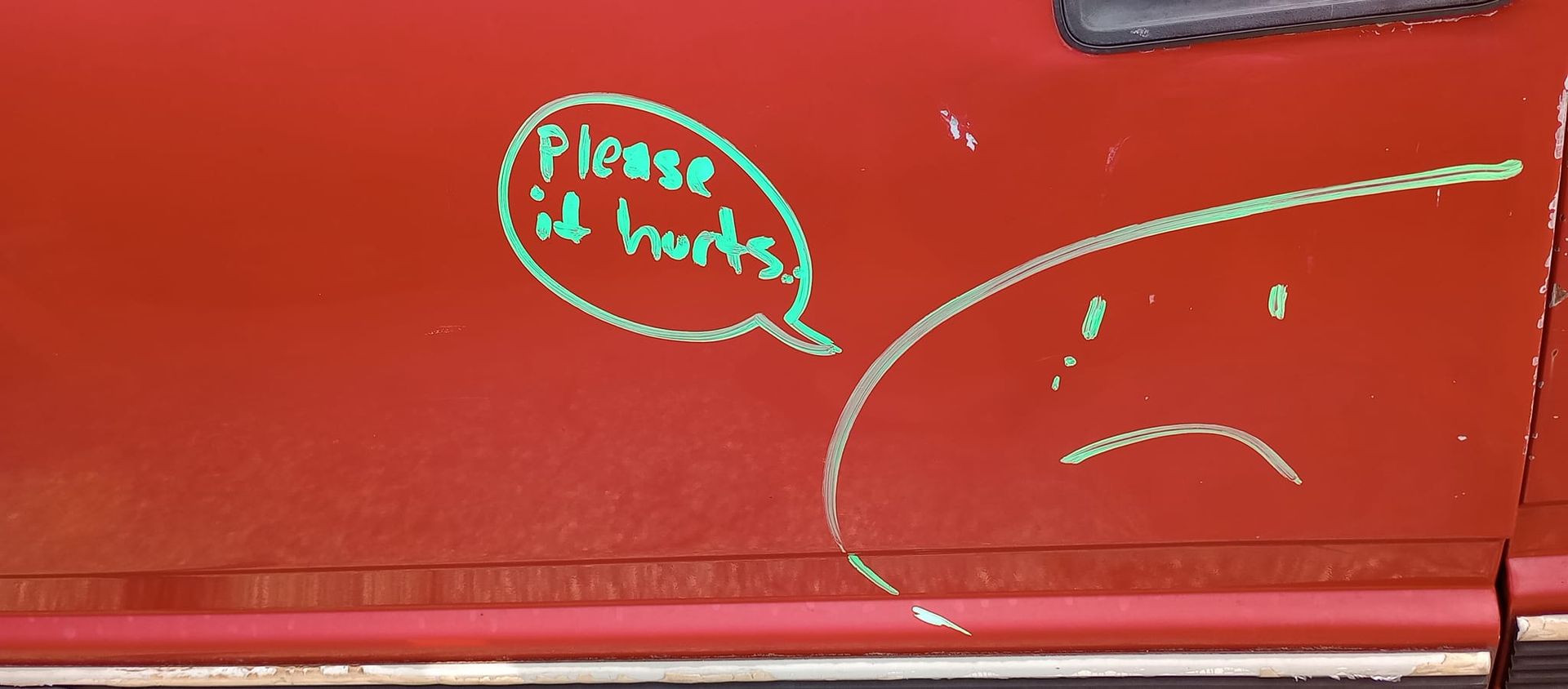 A red car with a sad face and a speech bubble that says please it hurts