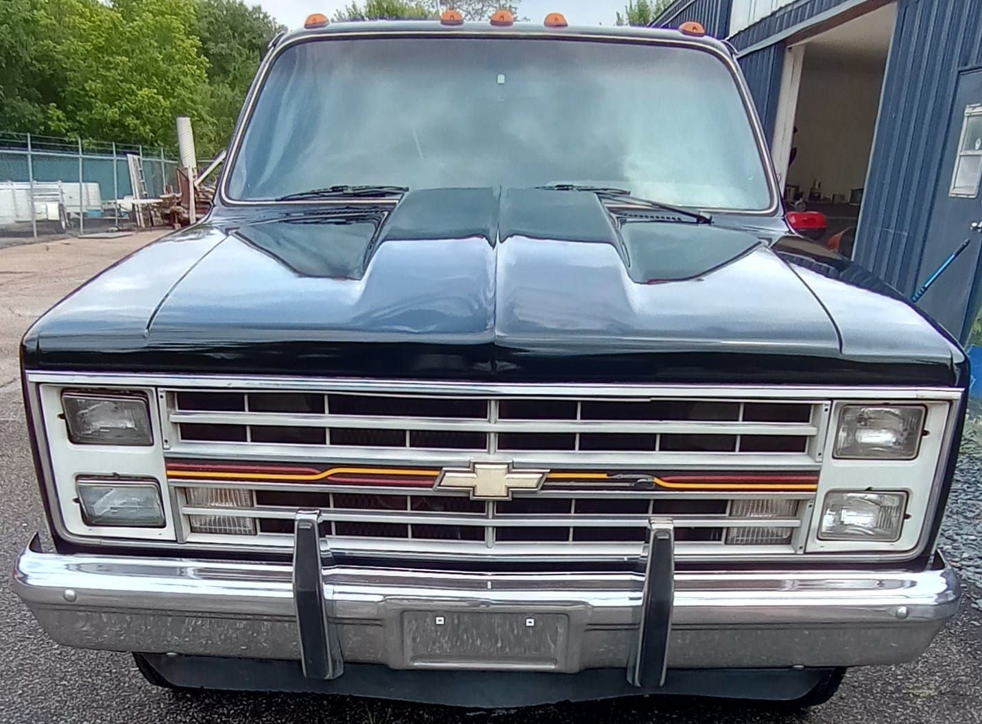 A black chevrolet truck is parked in front of a garage