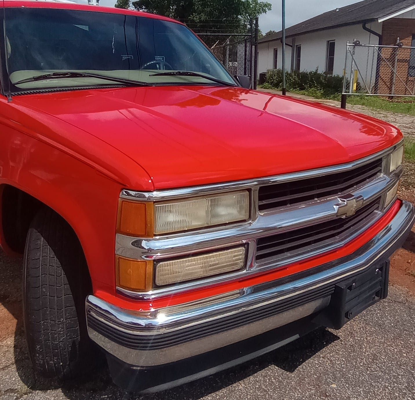 A red truck is parked on the side of the road