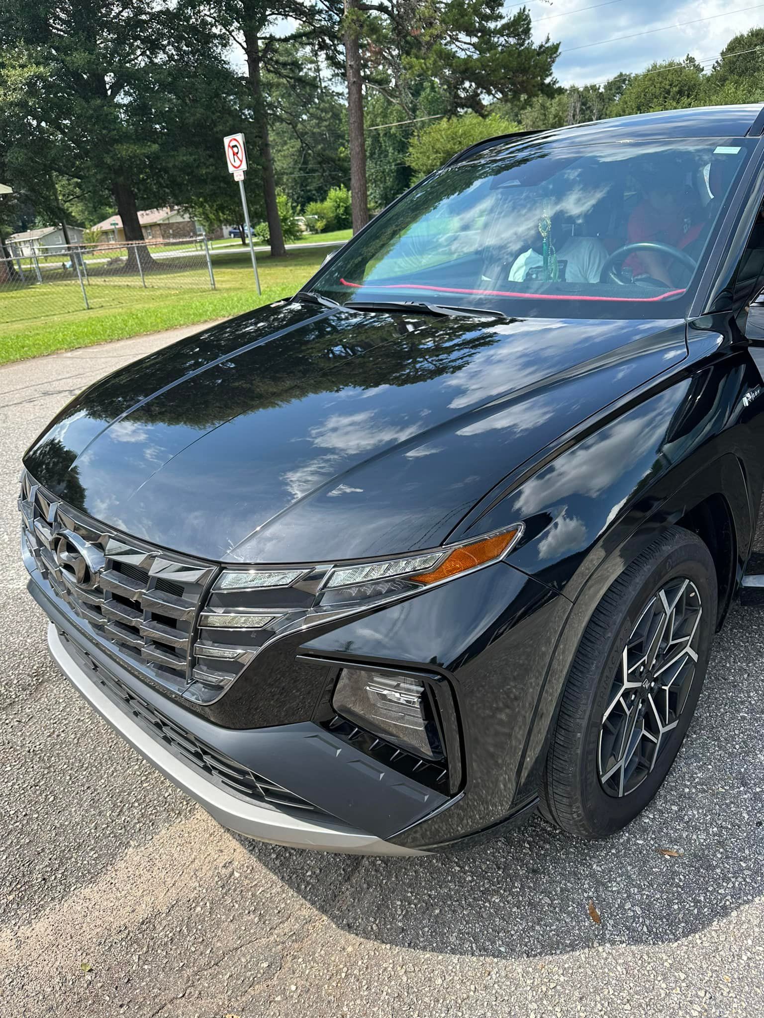 A black car is parked on the side of the road.
