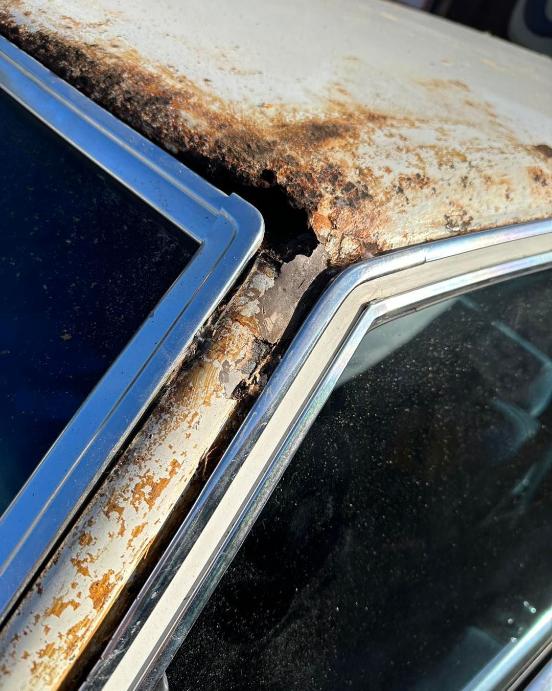 A close up of a car with rust on the roof