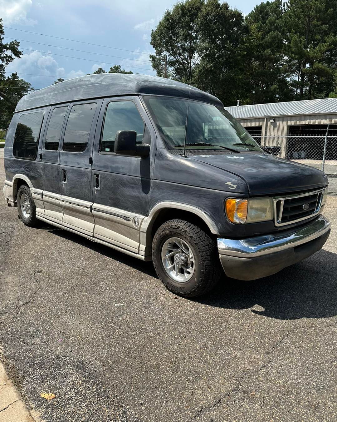 A blue van is parked on the side of the road.