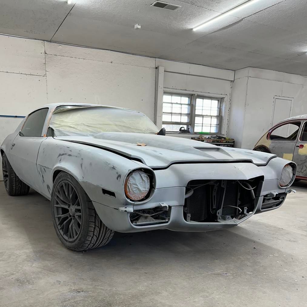 A white car is parked in a garage without a hood.
