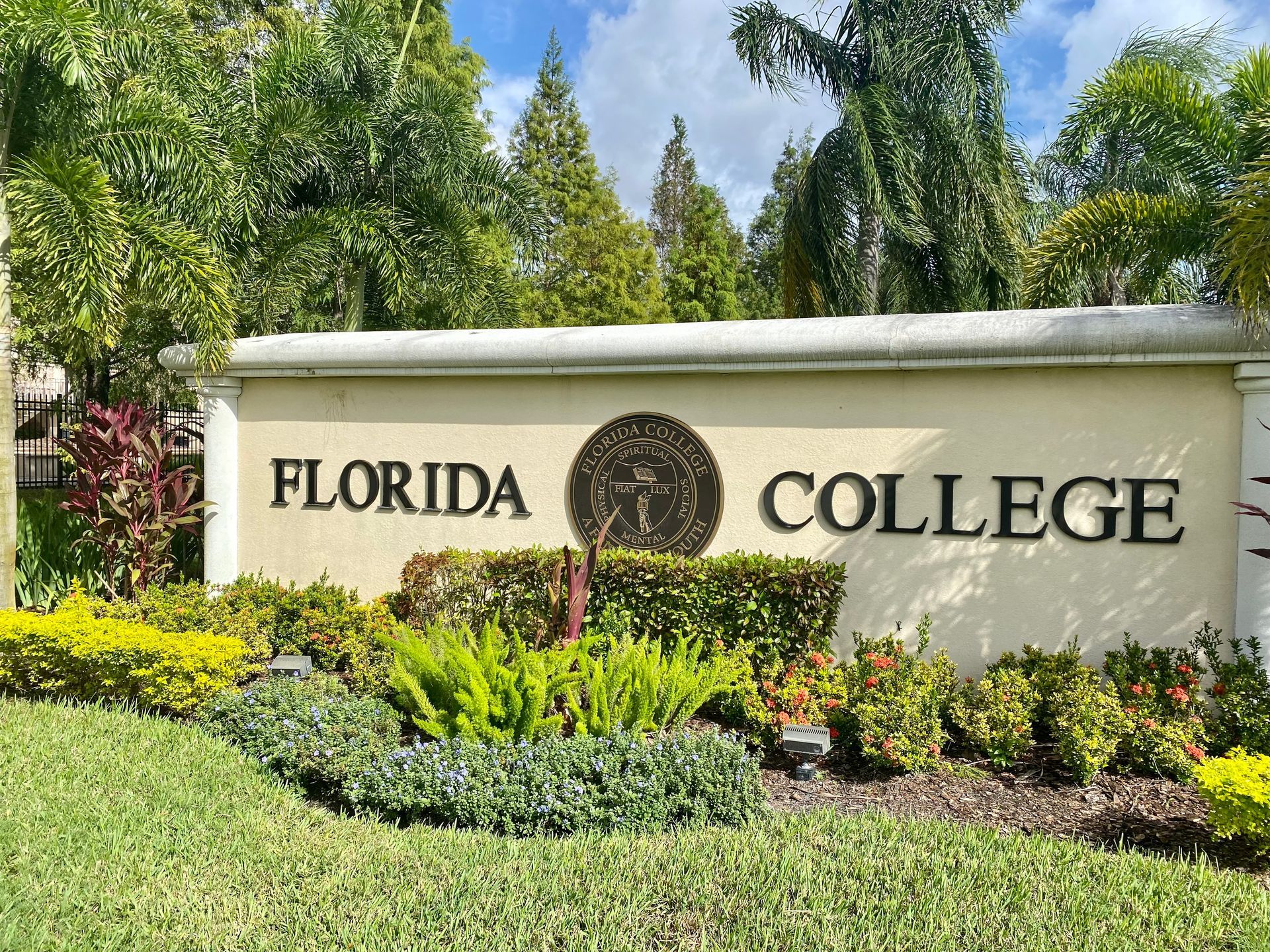 A sign for florida college is in the middle of a lush green field.