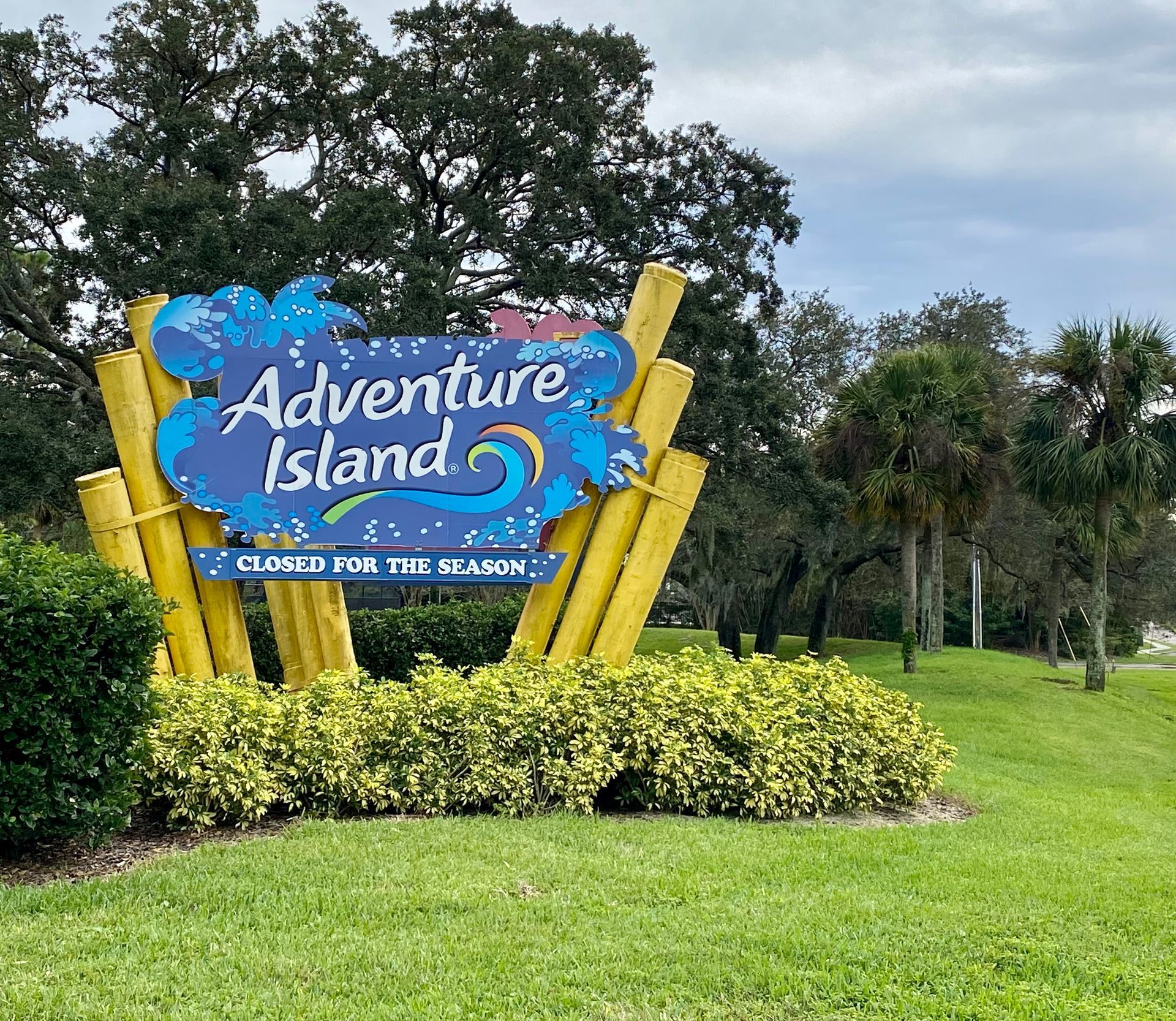 A sign for adventure island is sitting in the middle of a grassy field.- Crowders Landscaping