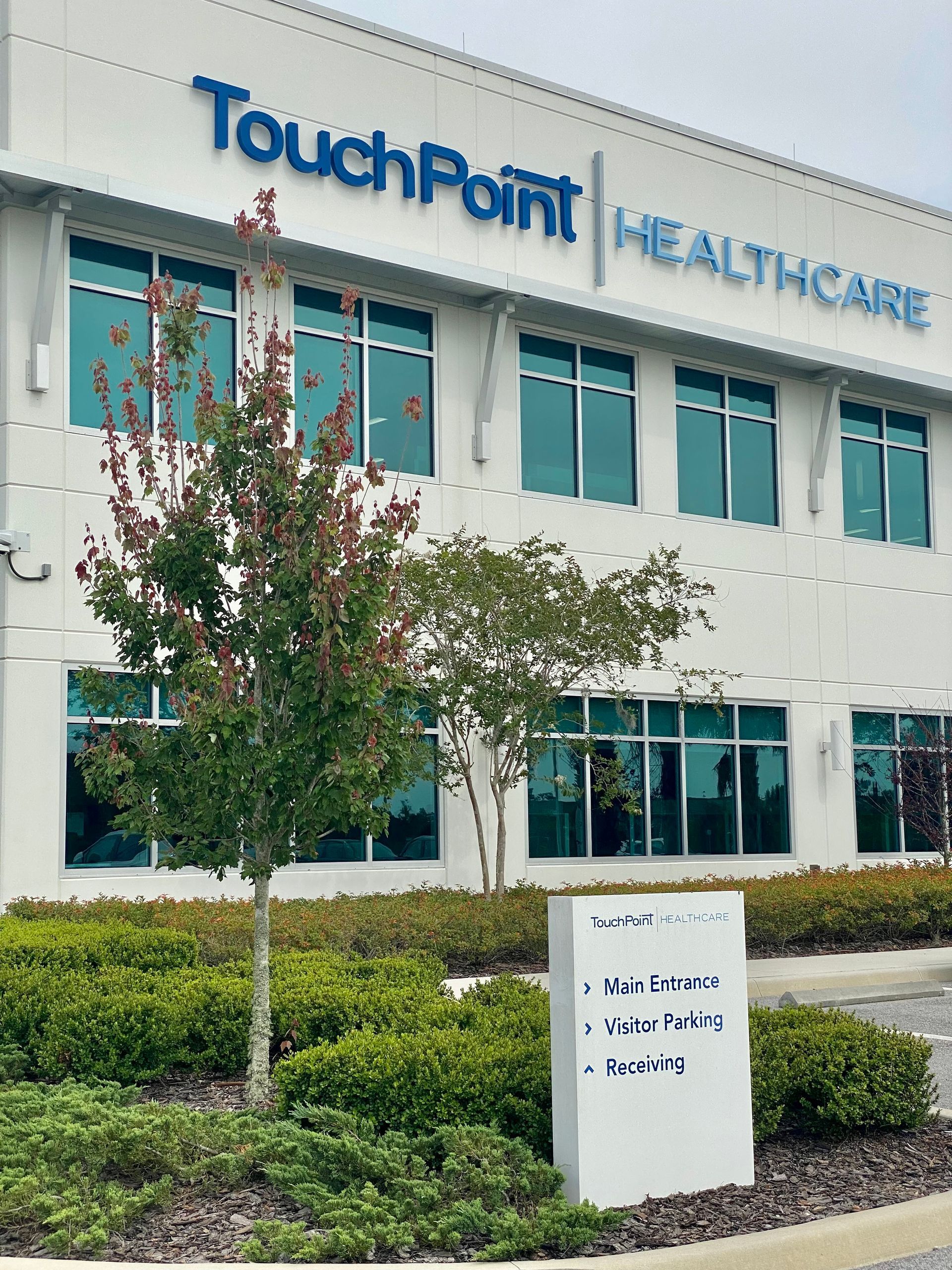 A touchpoint healthcare building with a sign in front of it