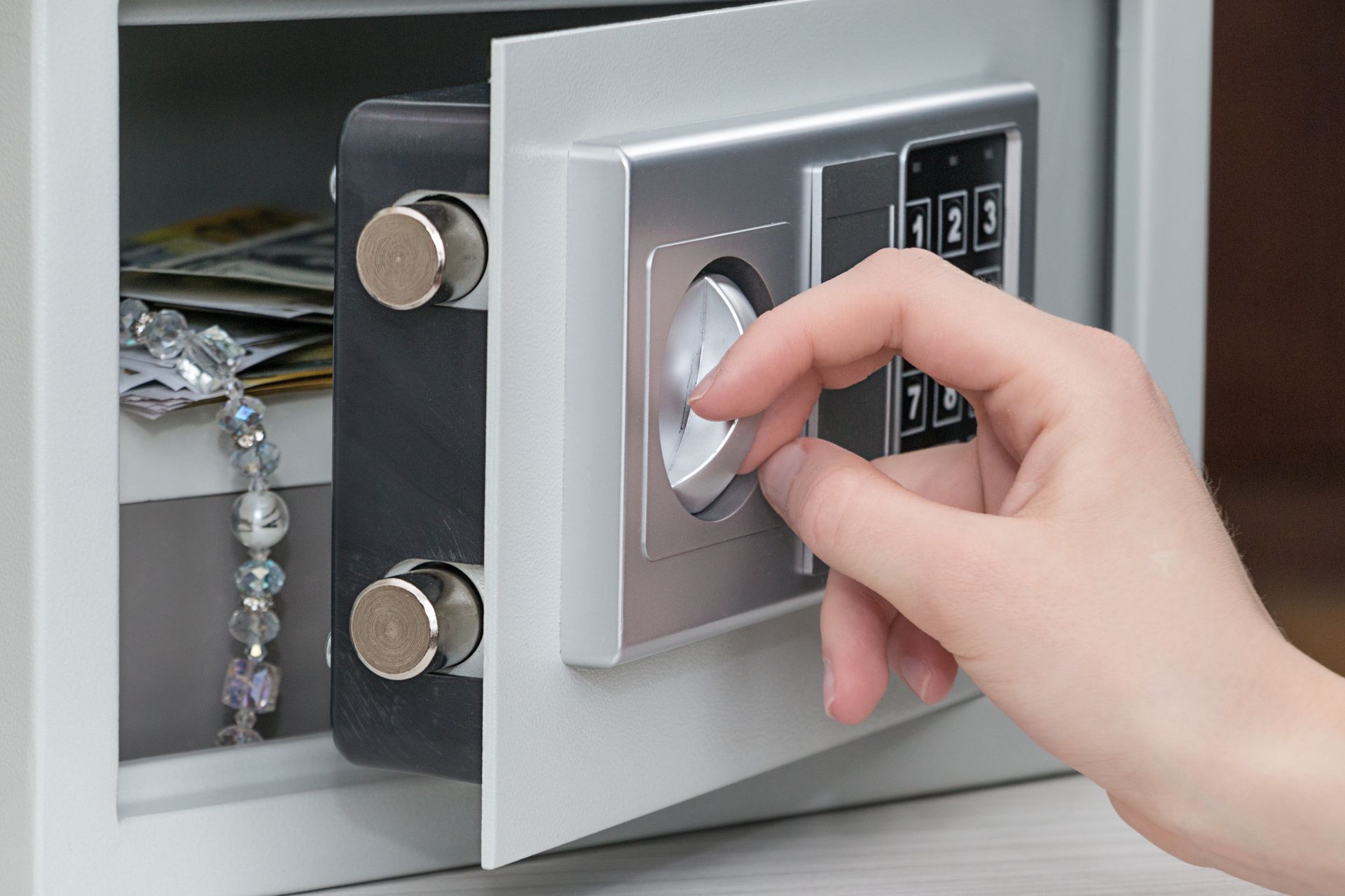 A person is opening a safe with a bracelet in it.
