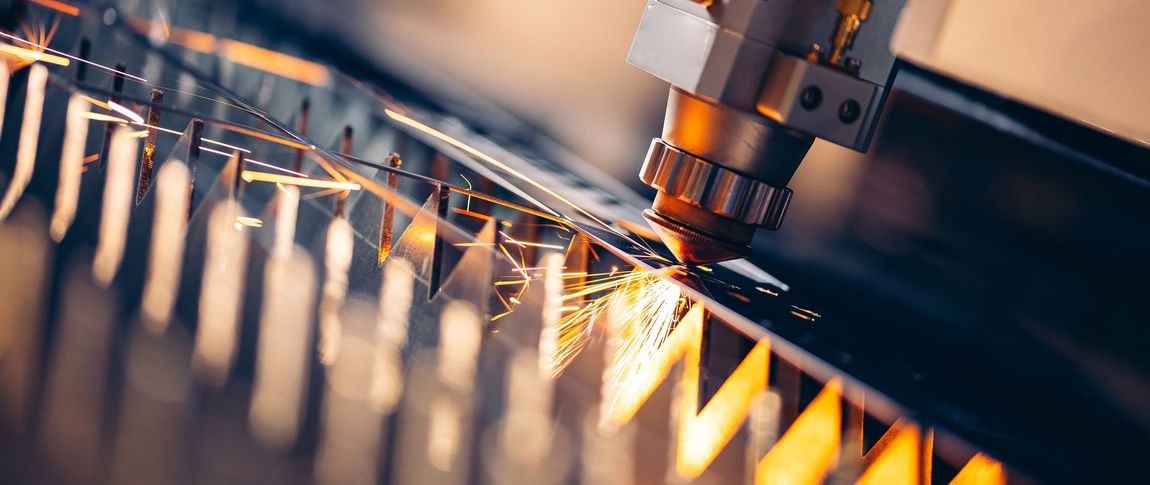 A machine is cutting a piece of metal with a lot of sparks coming out of it.