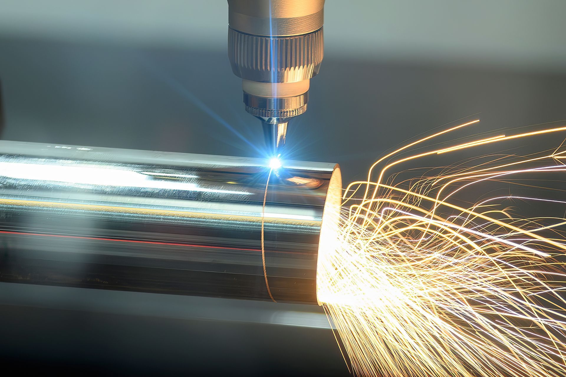 A machine is cutting a piece of metal with sparks coming out of it.