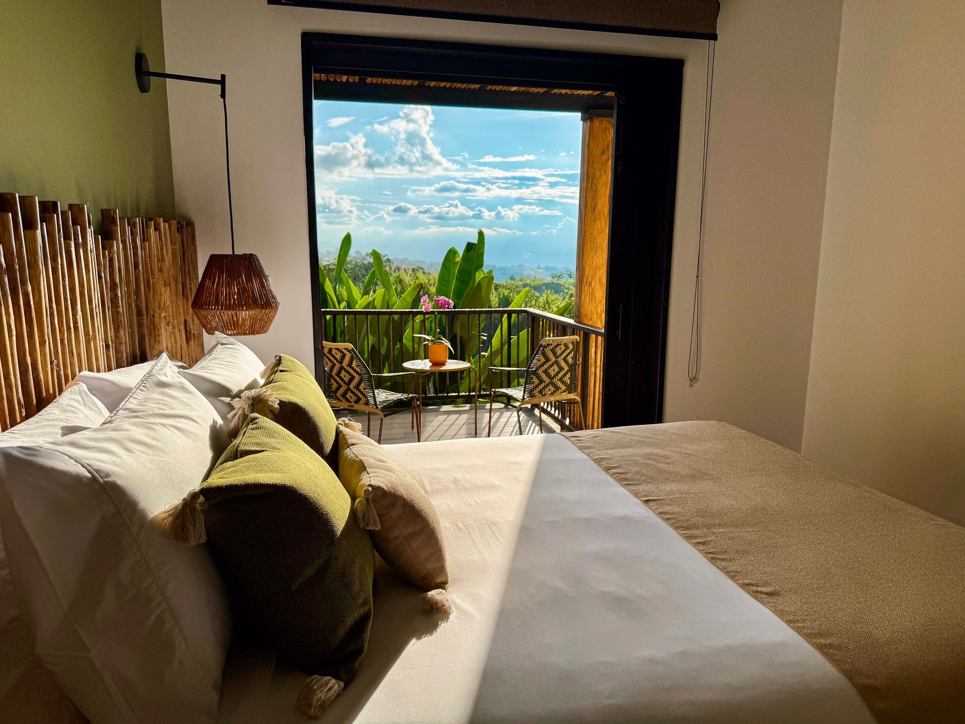Un dormitorio con una cama grande y un balcón con vista a las montañas.