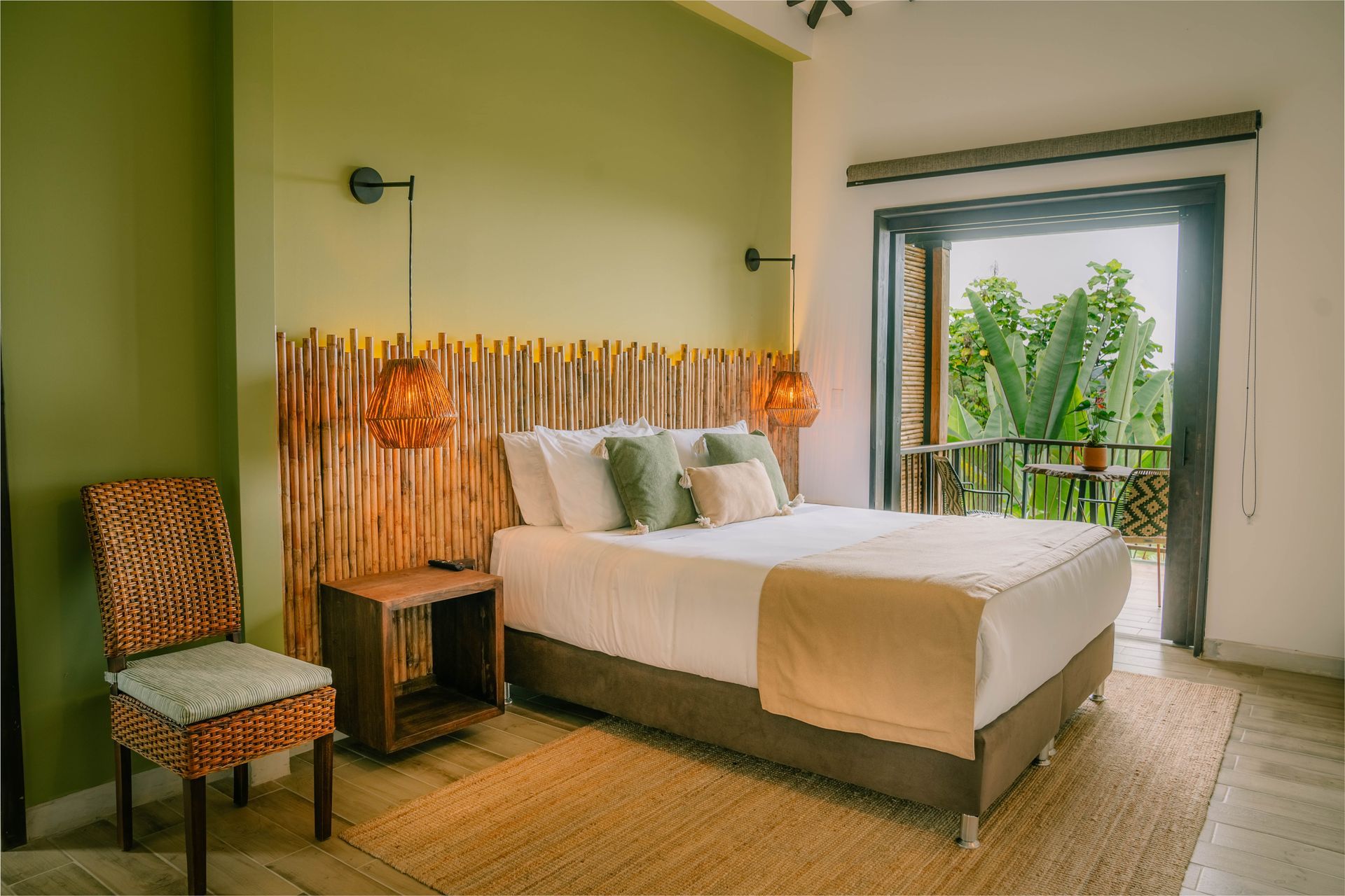 Un dormitorio con cama, silla, mesita de noche y puerta corrediza de vidrio.