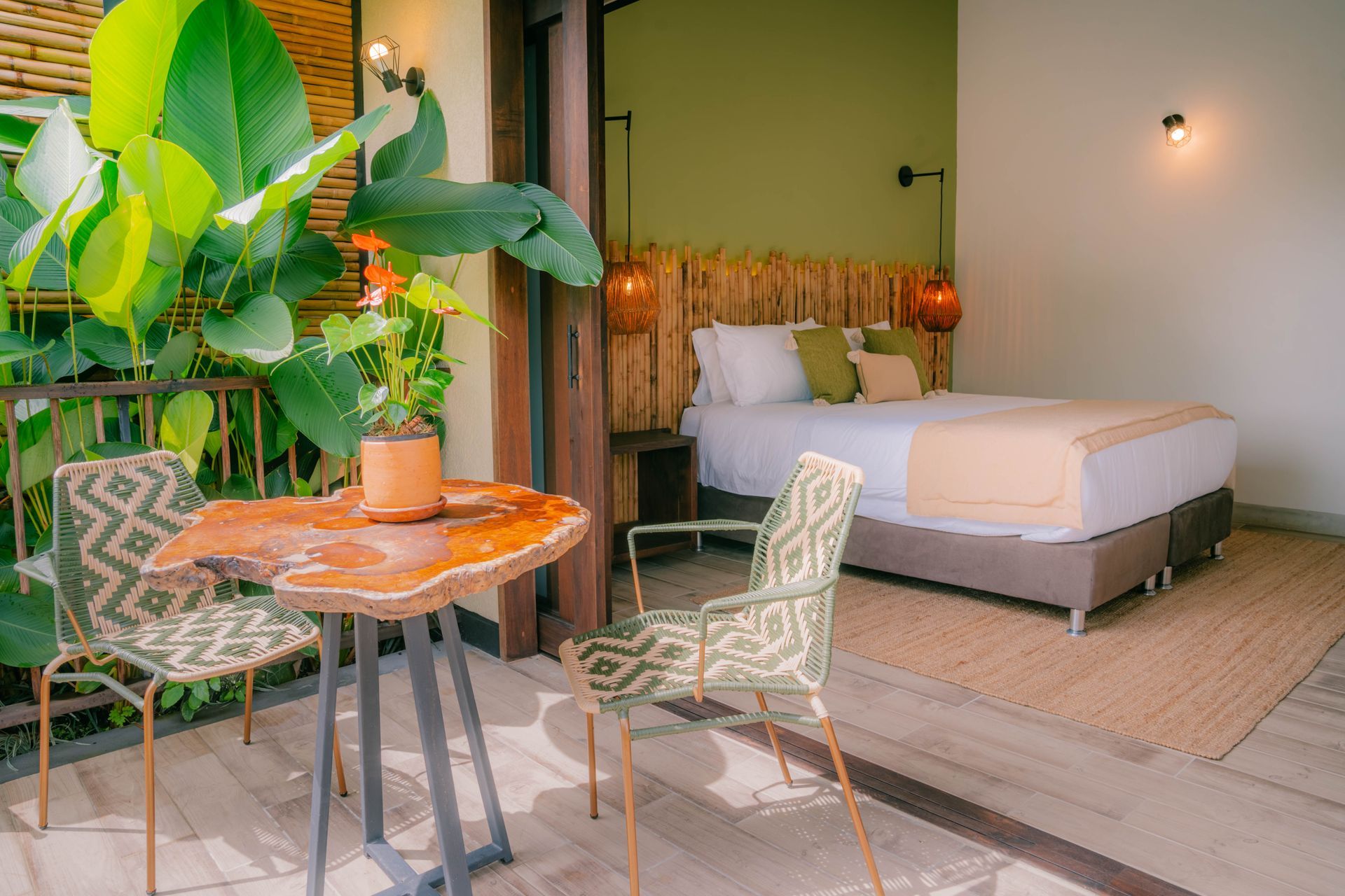 Una habitación de hotel con una mesa y sillas frente a una cama.