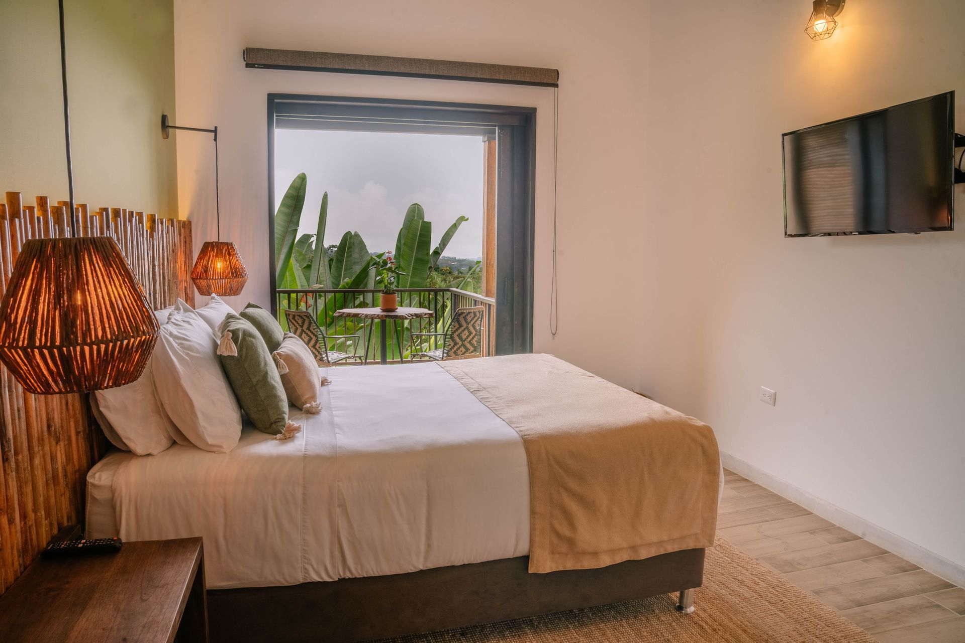 Un dormitorio con una cama grande, un televisor y un balcón.