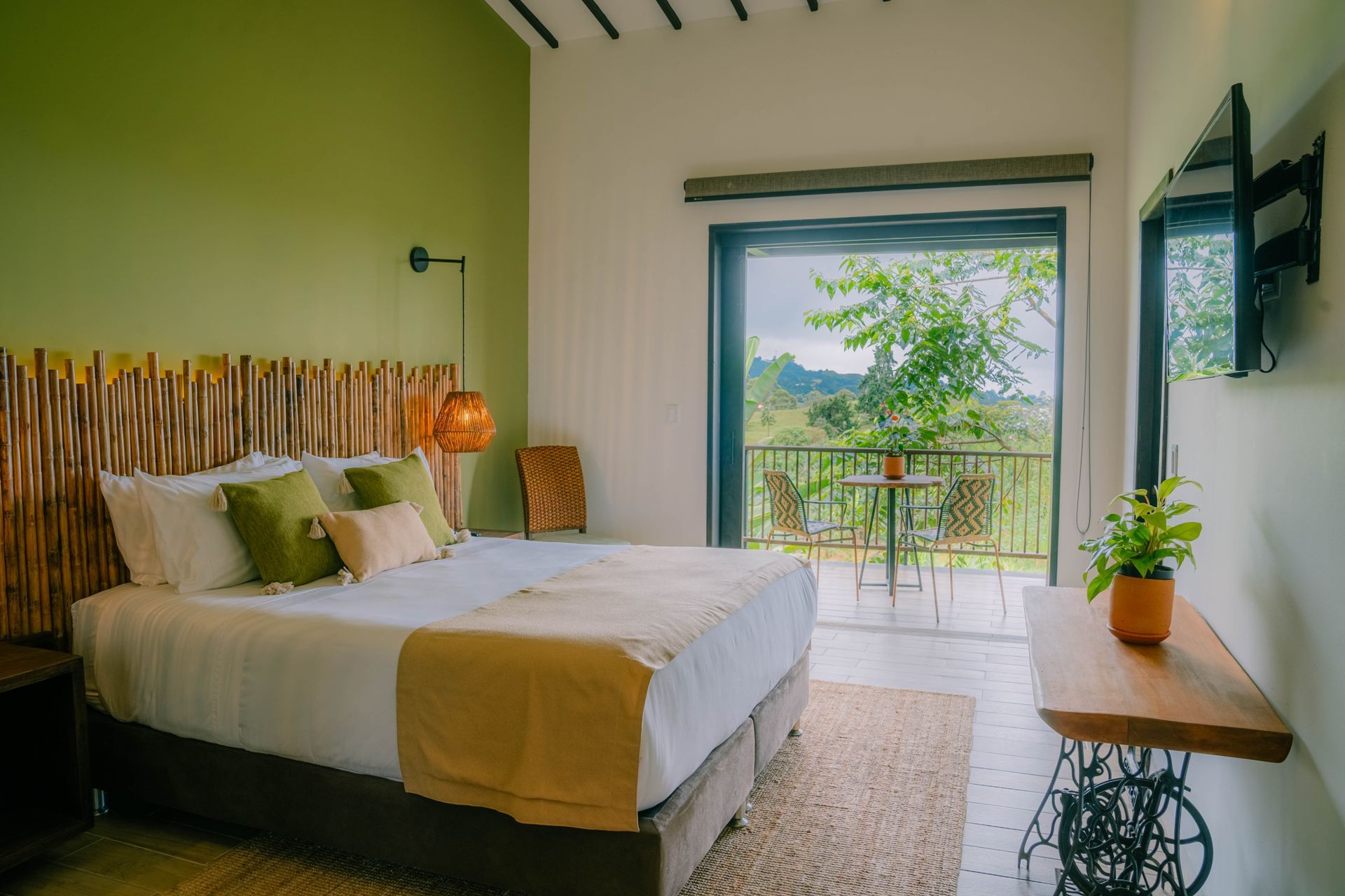 Un dormitorio con una cama grande, televisión y balcón.