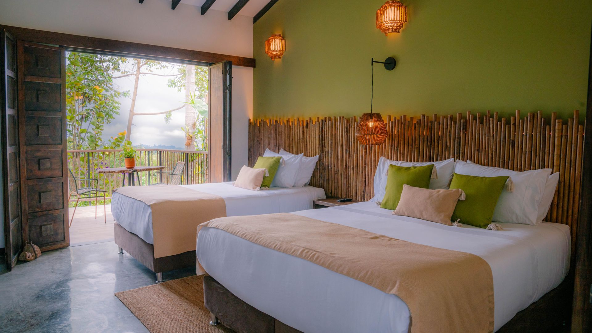 Una habitación de hotel con dos camas y una pared verde.