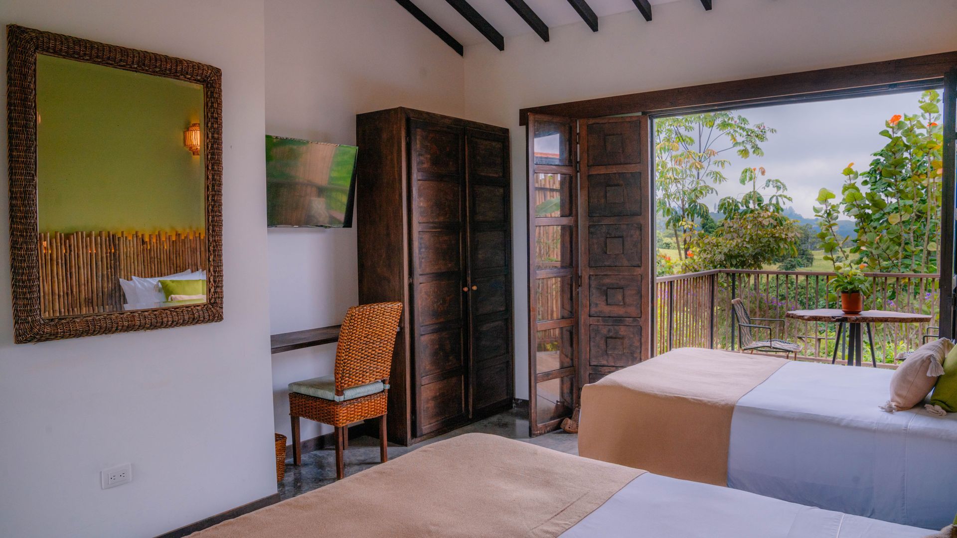 Una habitación de hotel con dos camas, un escritorio y un espejo.