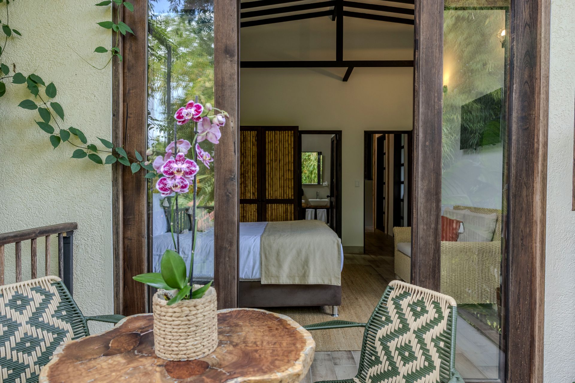 Una habitación de hotel con una mesa y sillas frente a una cama.