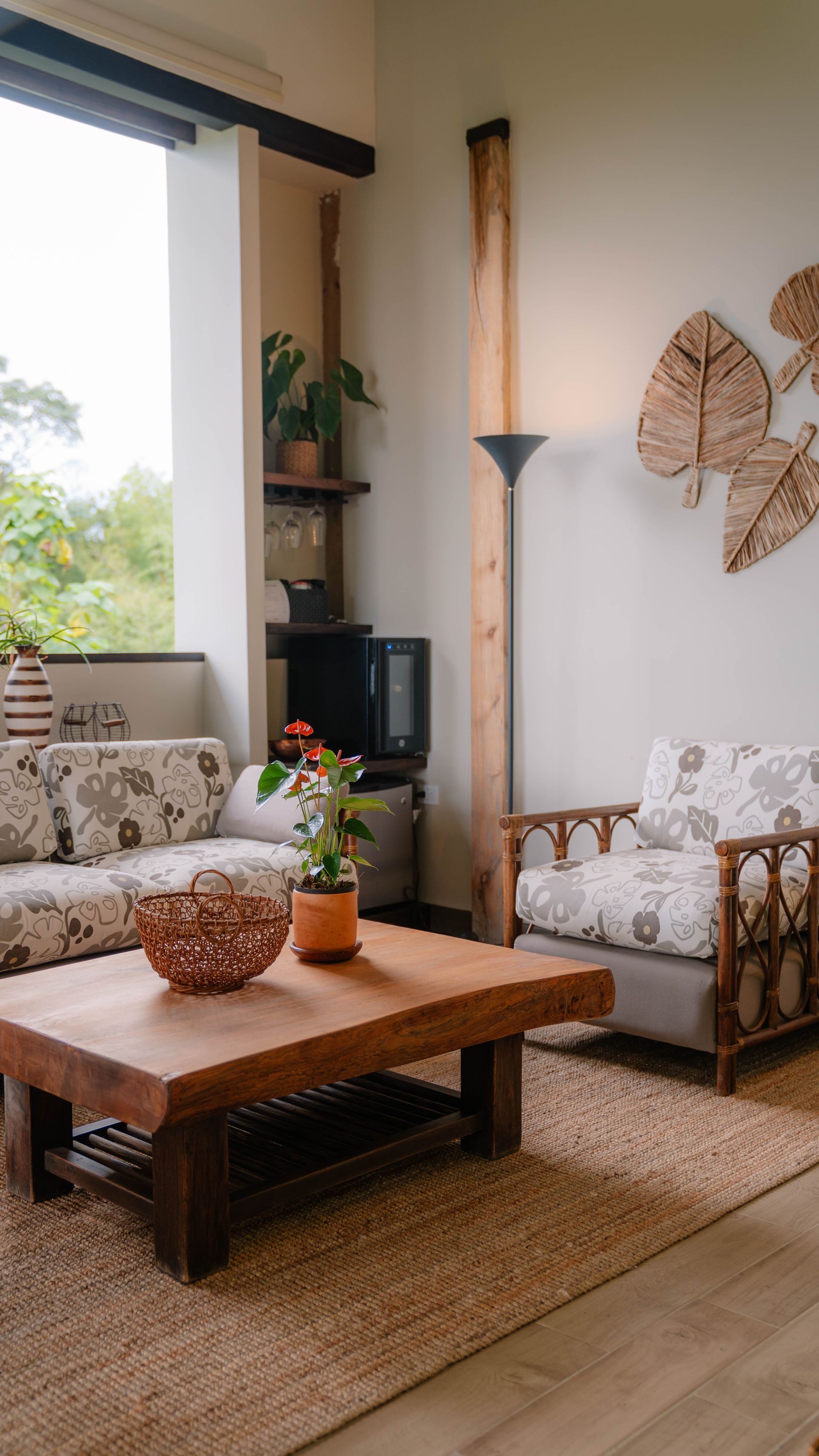 Una sala de estar con sofá, silla, mesa de café y ventana.