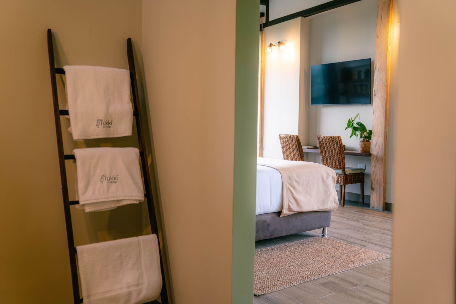 Una habitación de hotel con una escalera llena de toallas y una cama.