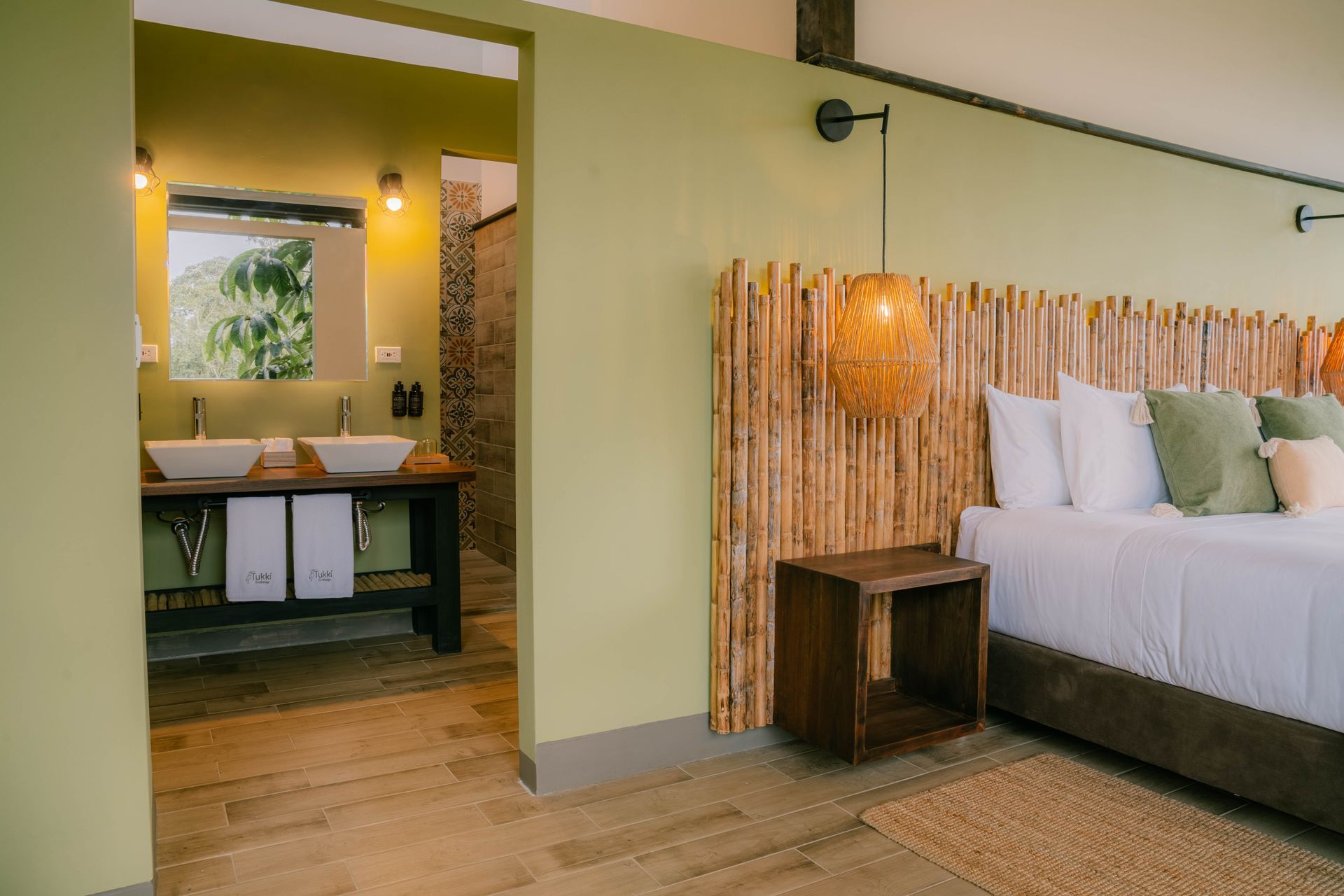 Un dormitorio con una cama y un baño con dos lavabos.