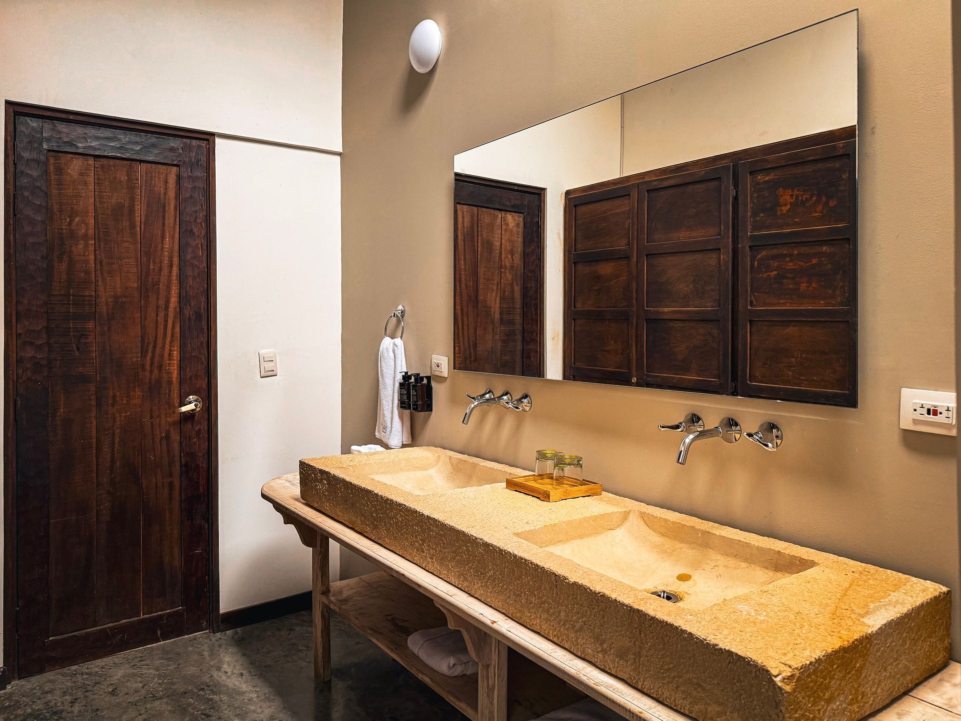 Un baño con dos lavabos y un espejo grande.