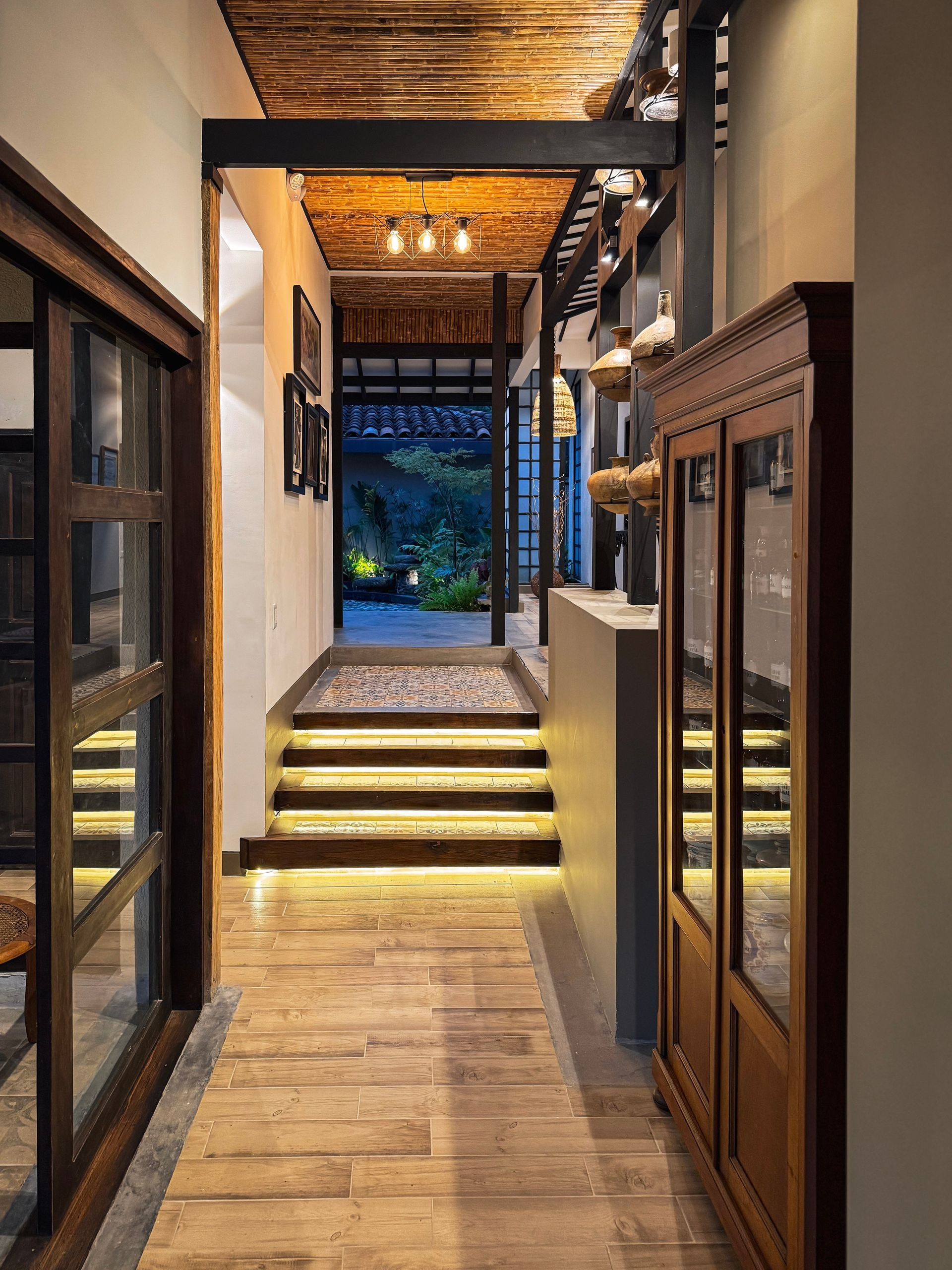 Un pasillo con suelo de madera y escaleras en una casa.