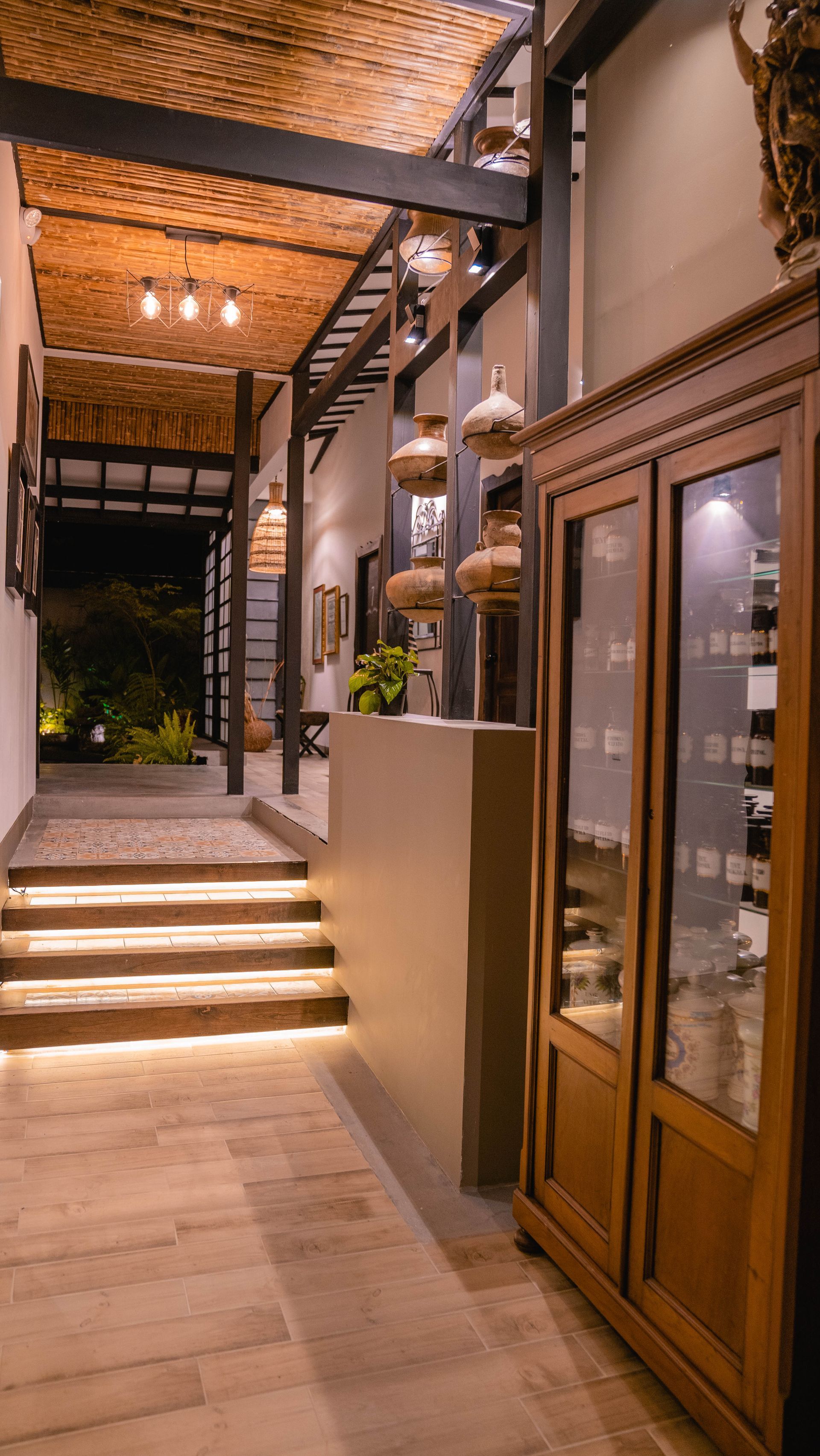 Un pasillo con escaleras que conducen a una vitrina de cristal.