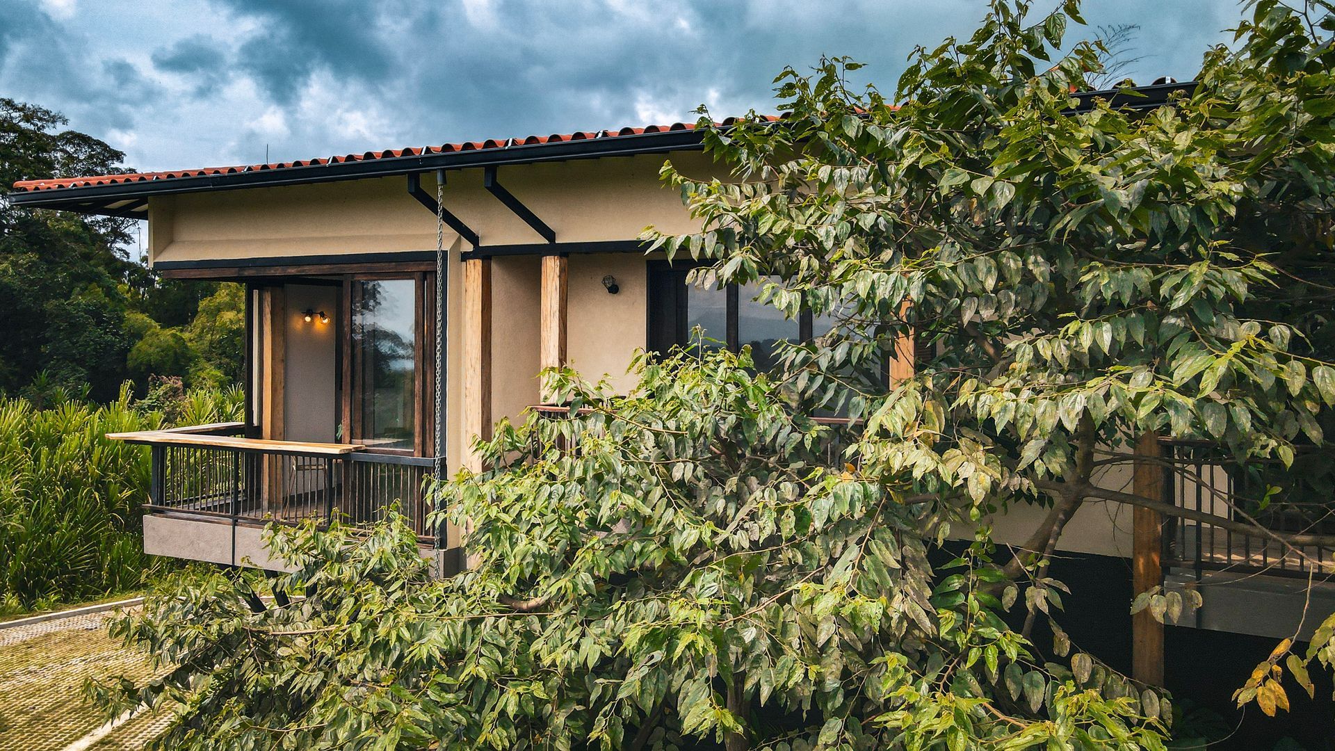 Una pequeña casa está rodeada de árboles y arbustos.