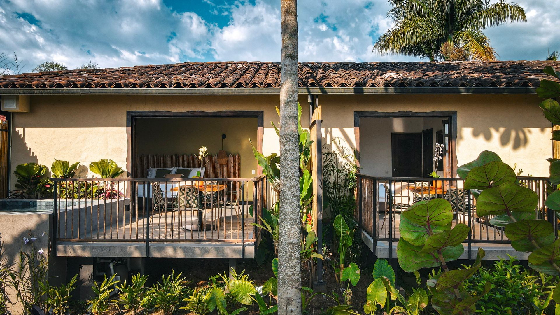 Una casa con un balcón y una palmera delante de ella.
