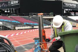 A man wearing a hard hat is working on a stadium.