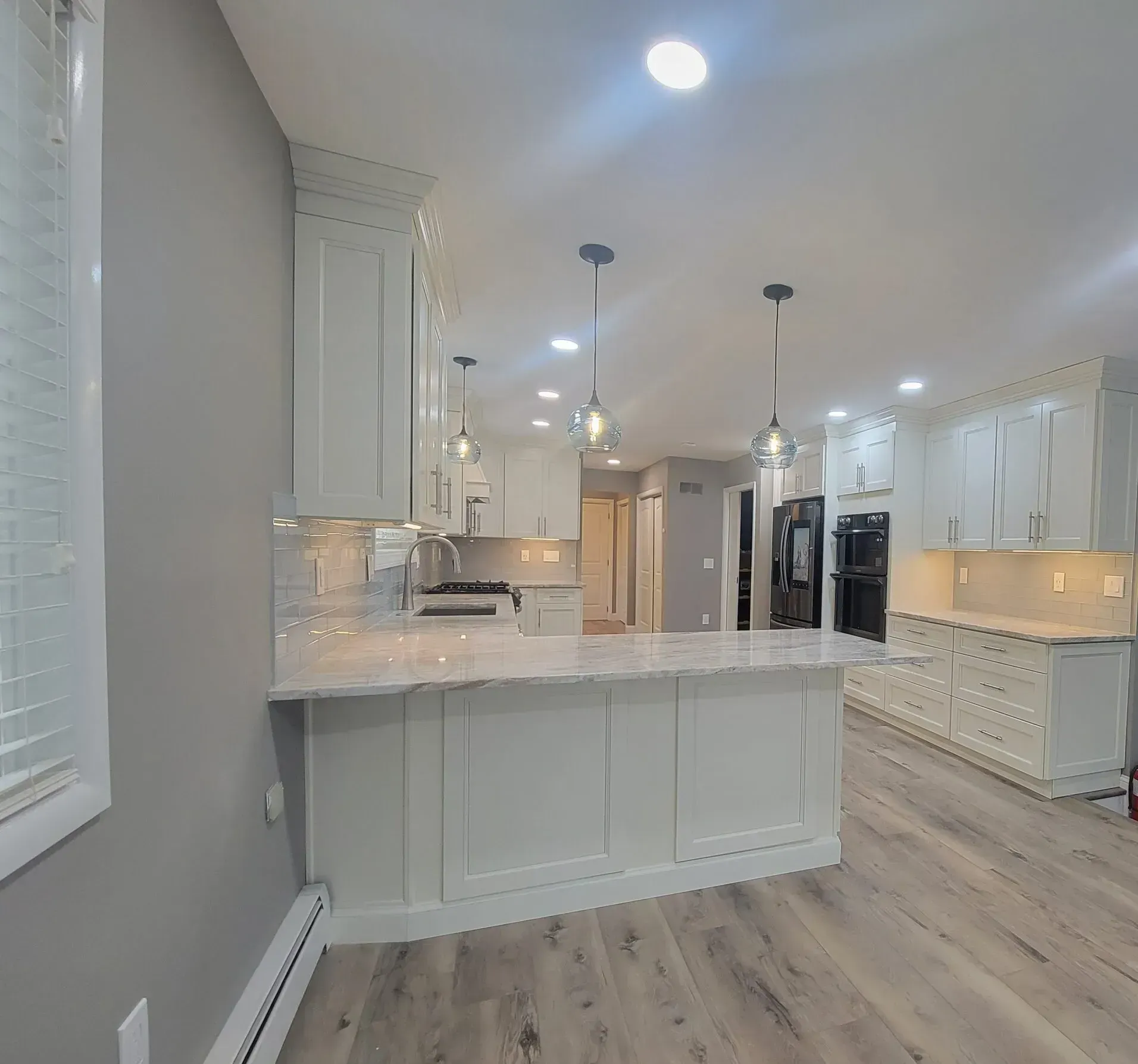 A kitchen with white cabinets and a large island