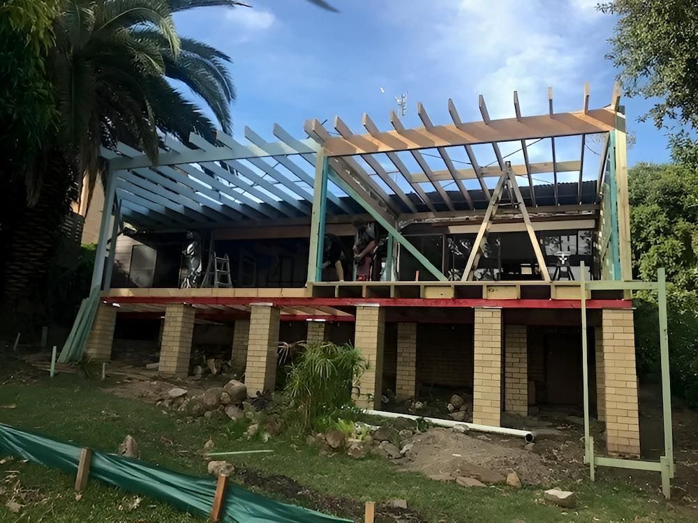 A House is Being Built on Stilts With a Wooden Roof — East Maitland Building In Newcastle, NSW
