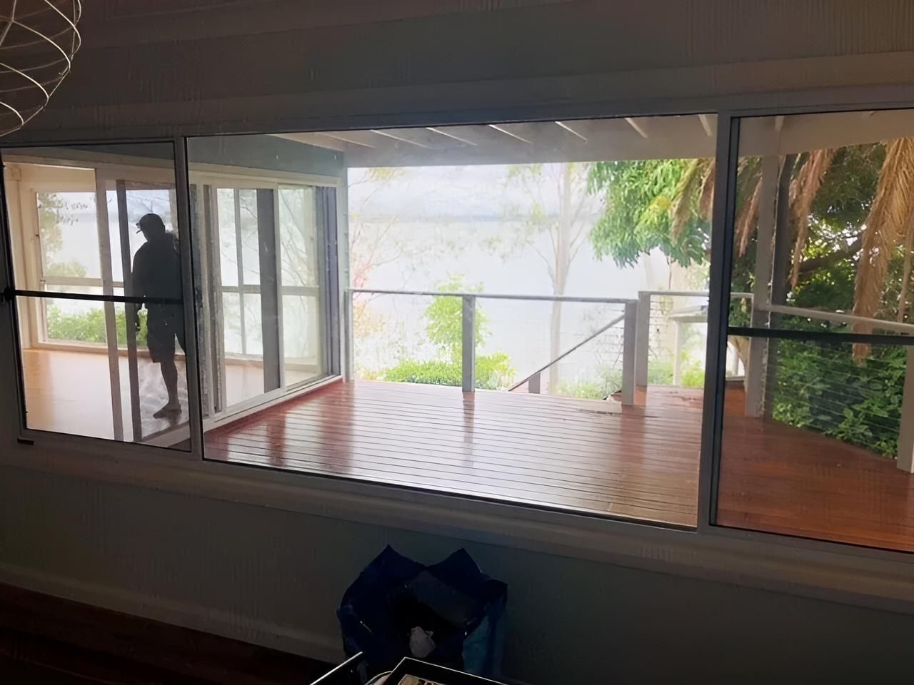 A Man is Standing in Front of a Window Overlooking a Deck — East Maitland Building In Maitland, NSW