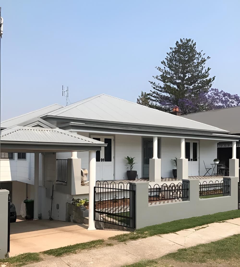 A White House With a Porch and a Fence in Front of It — East Maitland Building In Tenambit, NSW