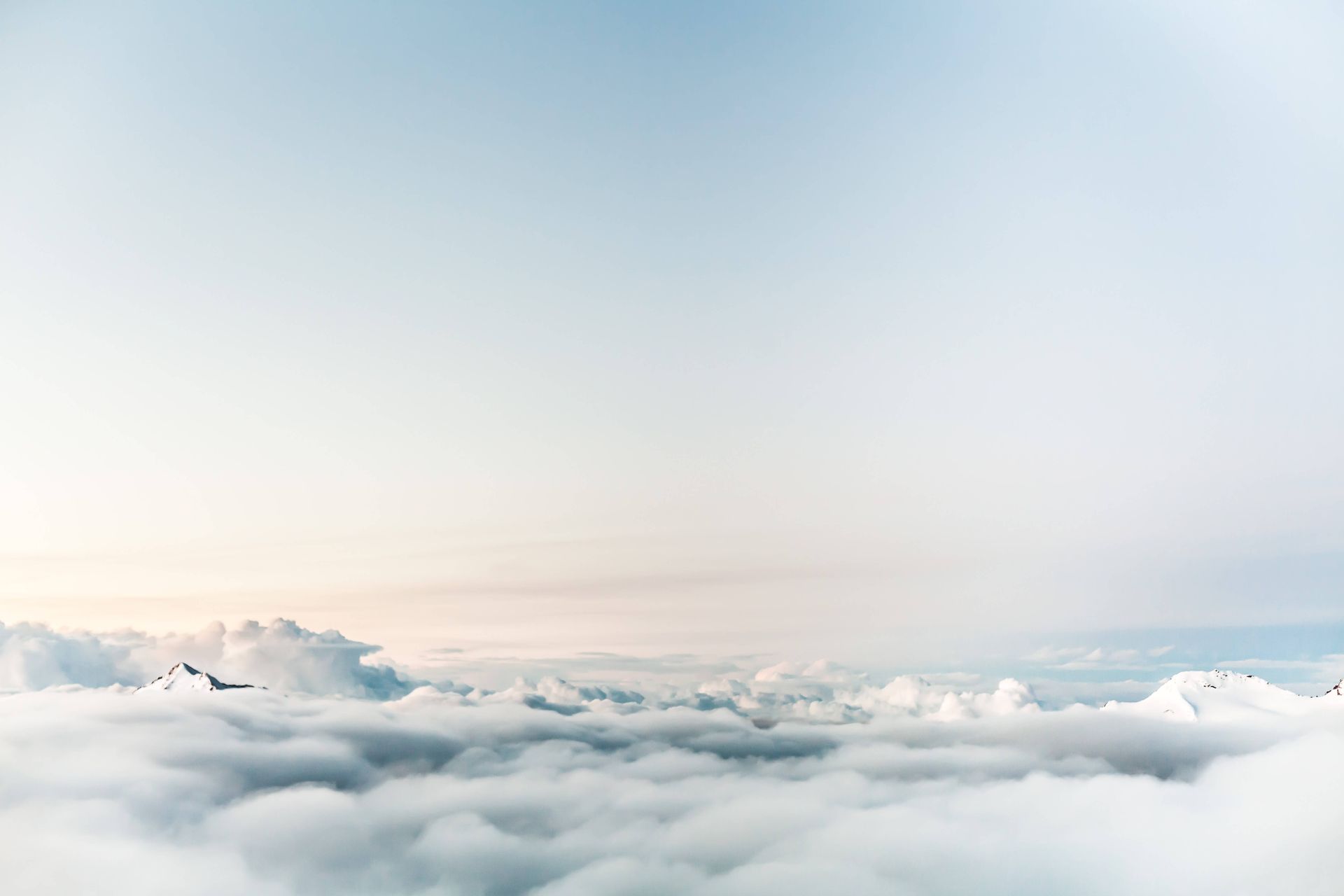 A plane is flying through the clouds in the sky.