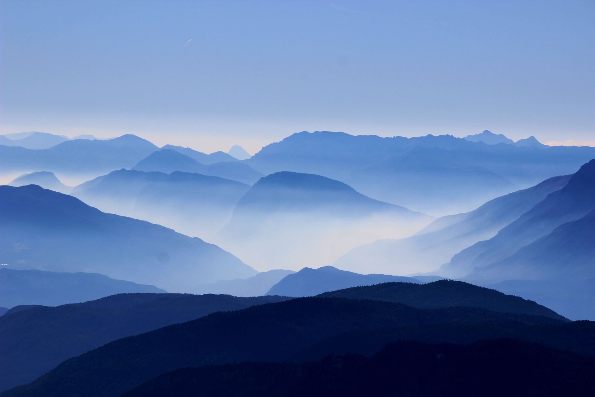 The mountains are covered in fog and the sky is blue.