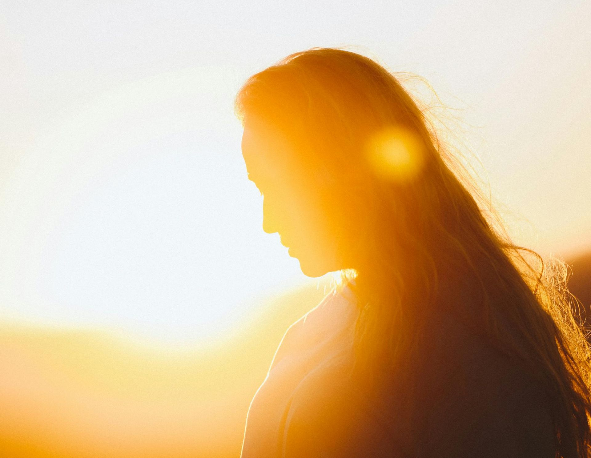 The dark silhouette of a person illuminated by a sunrise.