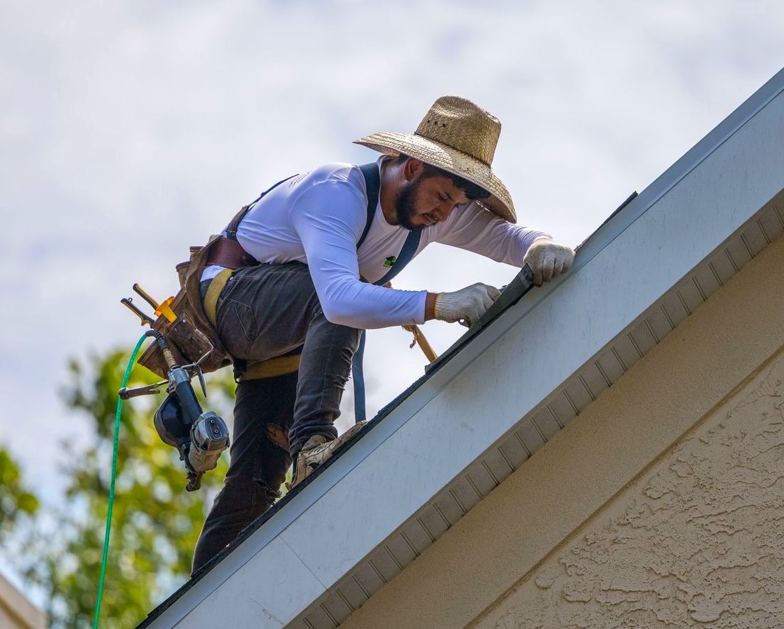 Photo of a man repairing a roofing shingle.