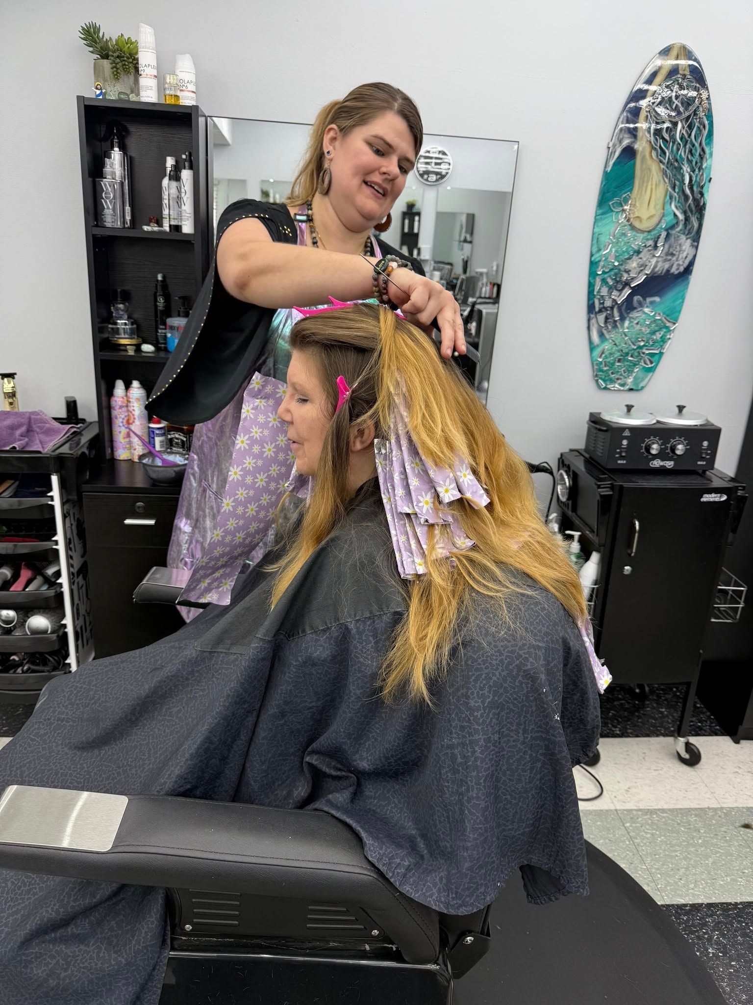 A woman is getting her hair dyed in a salon.