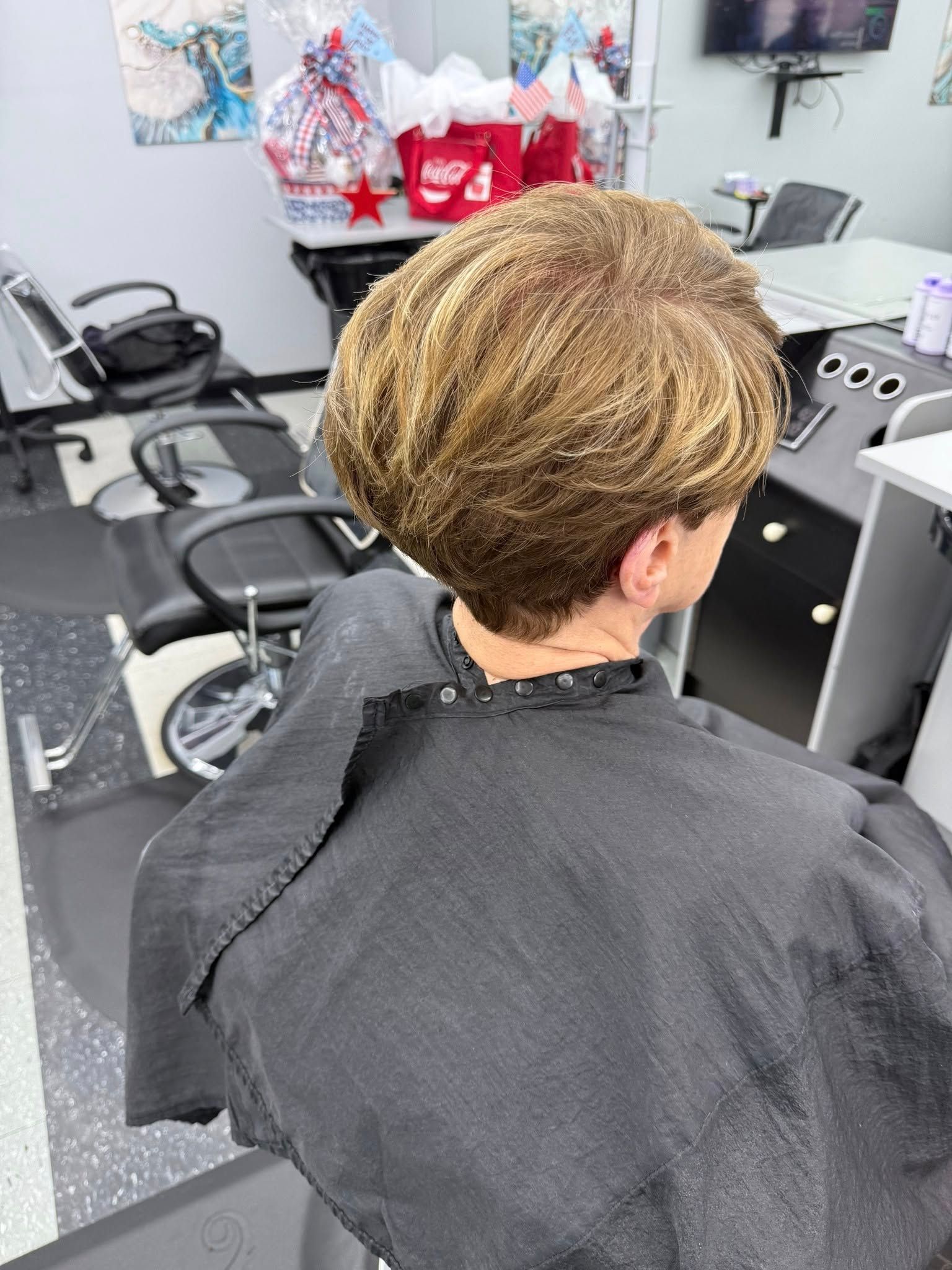 A person is getting their hair cut in a salon.