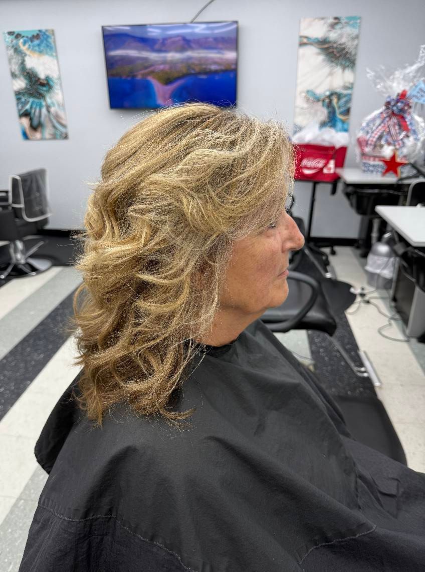 A woman is getting her hair cut in a salon.