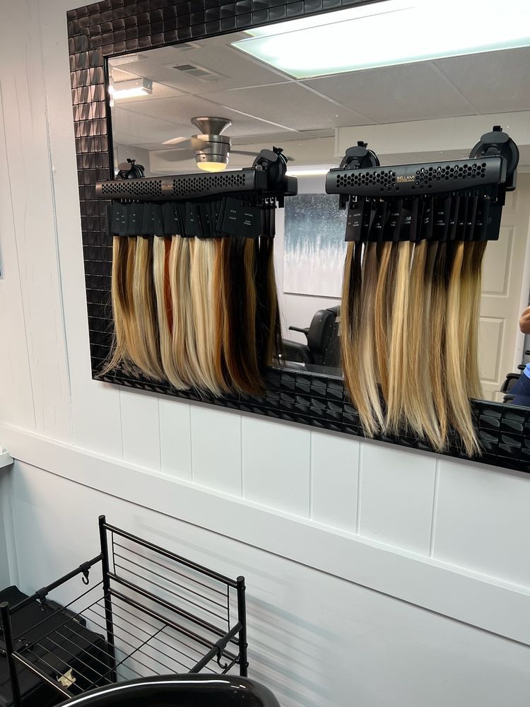 A mirror with a bunch of hair extensions on it.