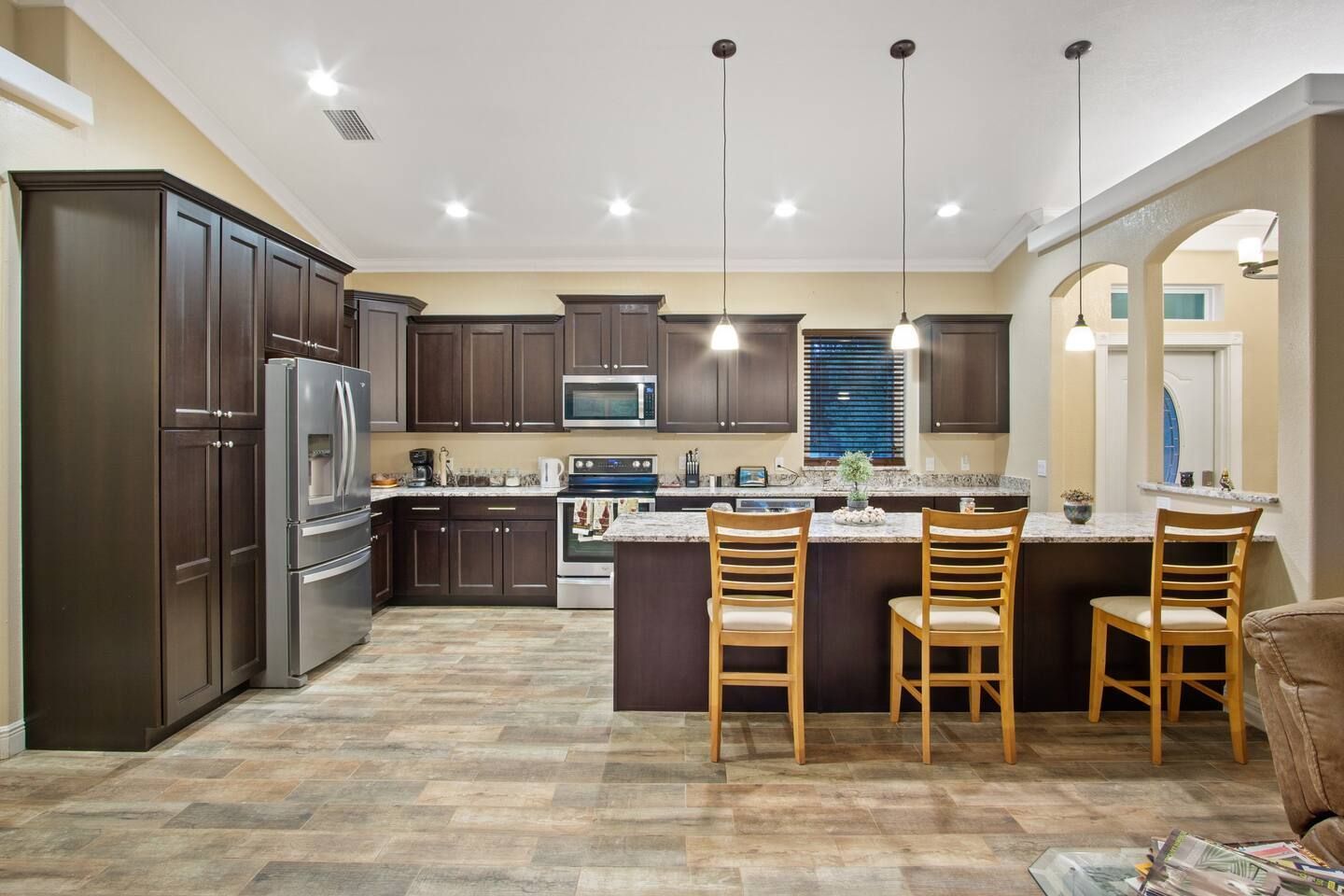 A kitchen with stainless steel appliances , wooden cabinets and a large island.