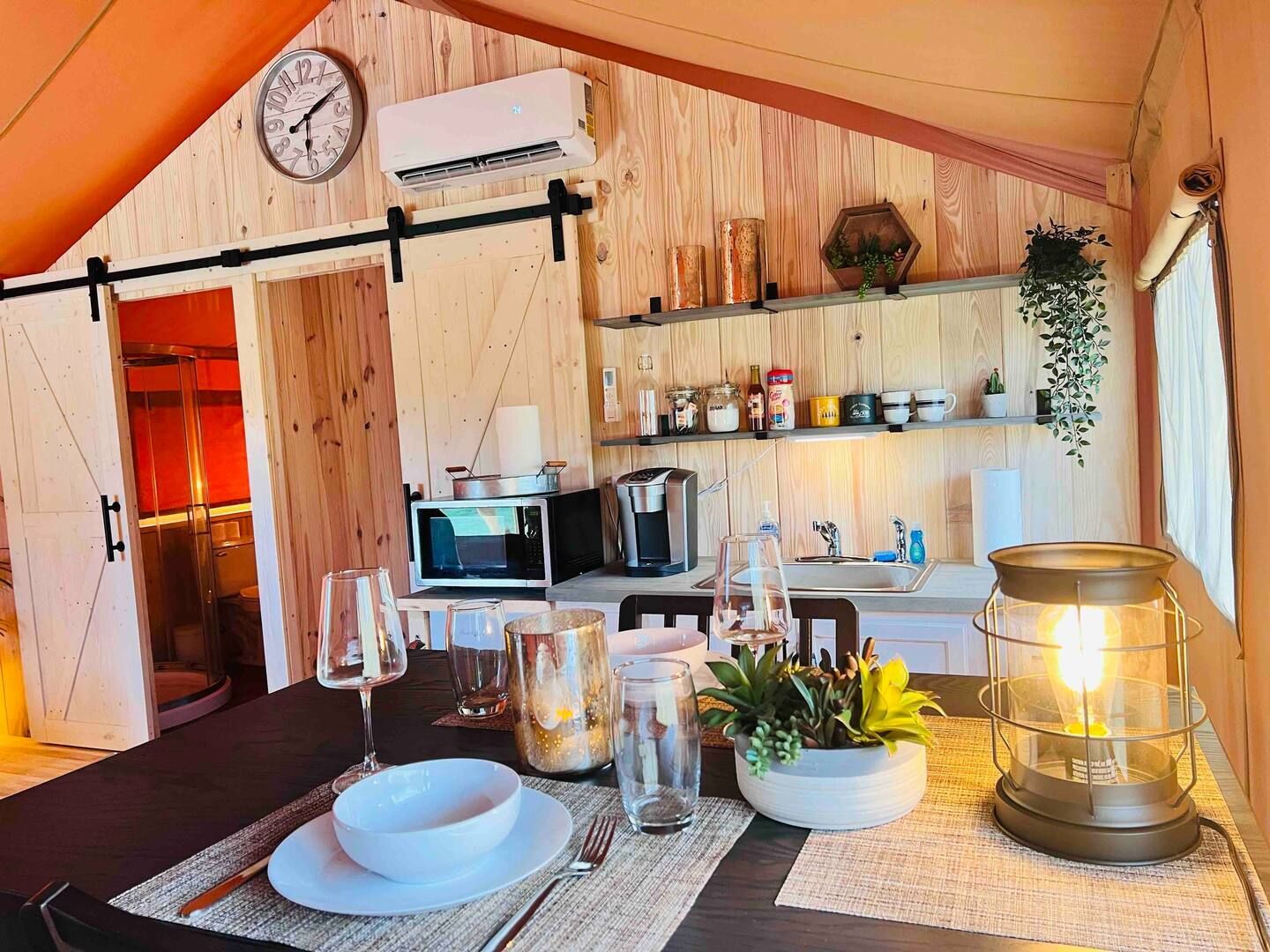 A kitchen with a table and a clock on the wall.