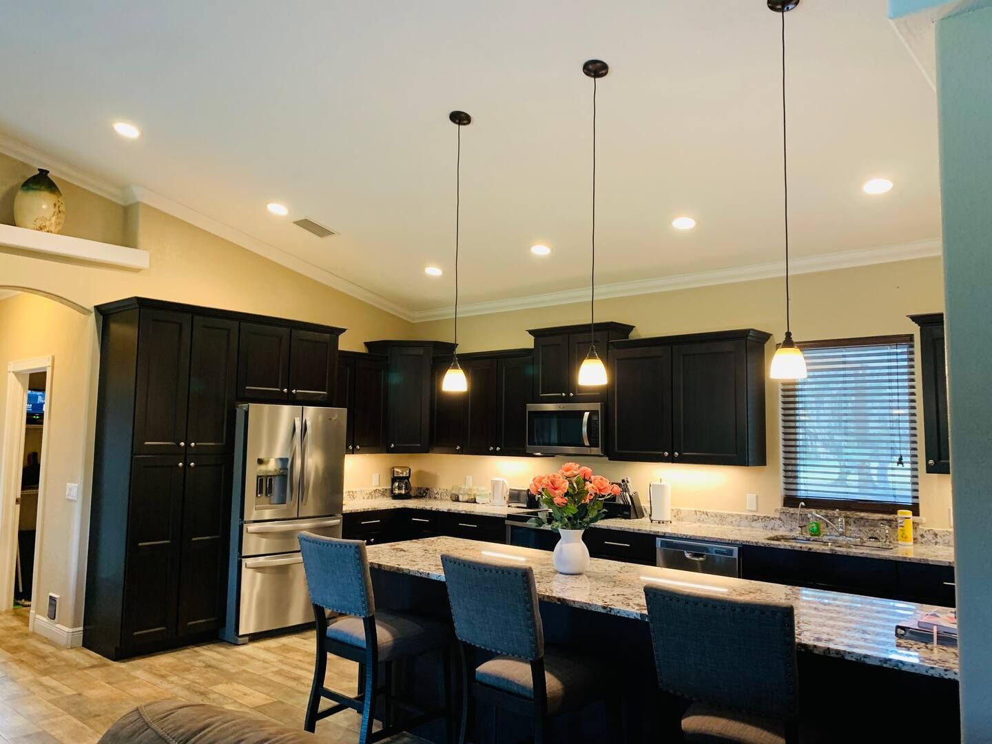 A kitchen with black cabinets and stainless steel appliances