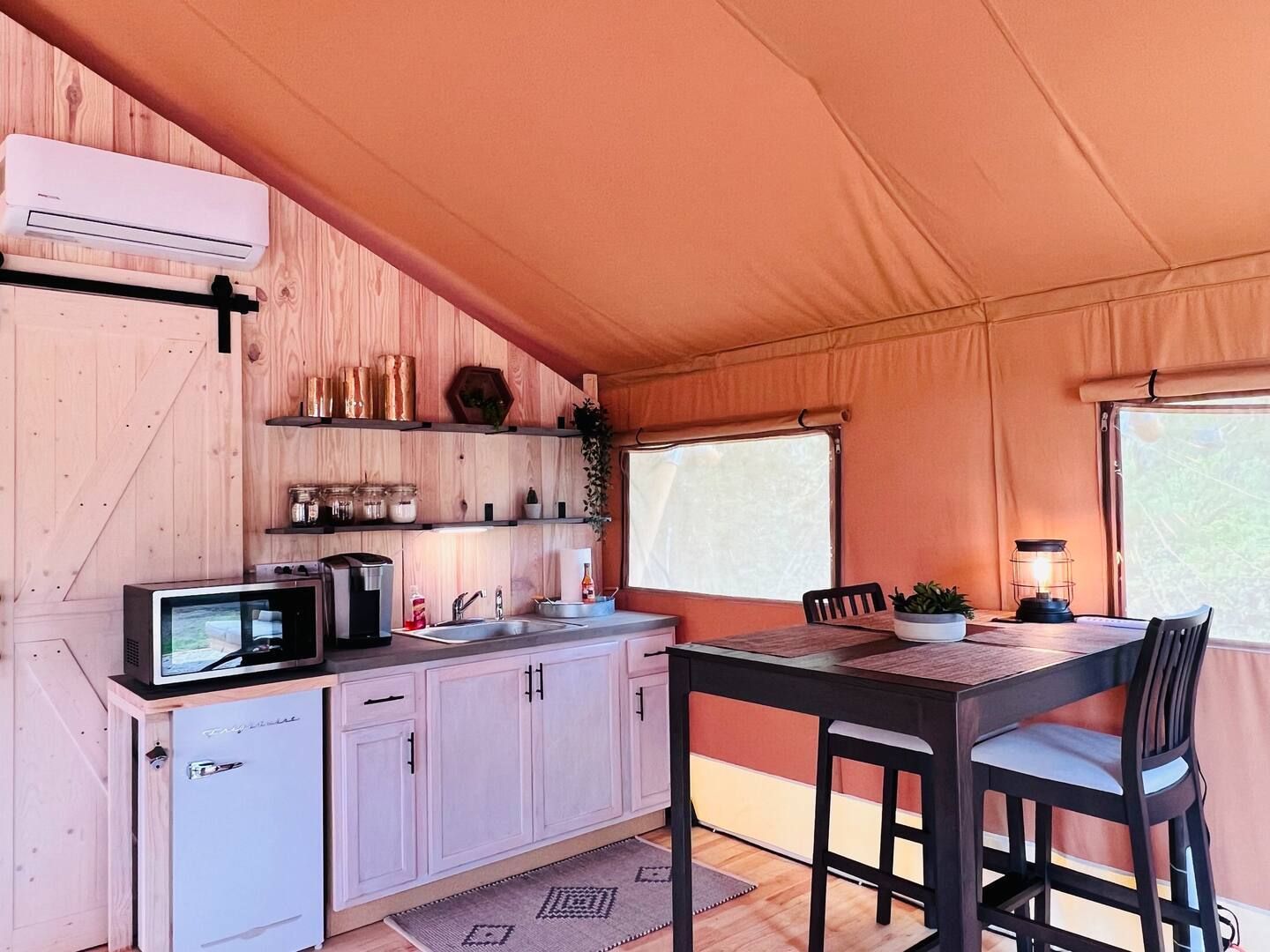 A kitchen with a table and chairs in a tent.