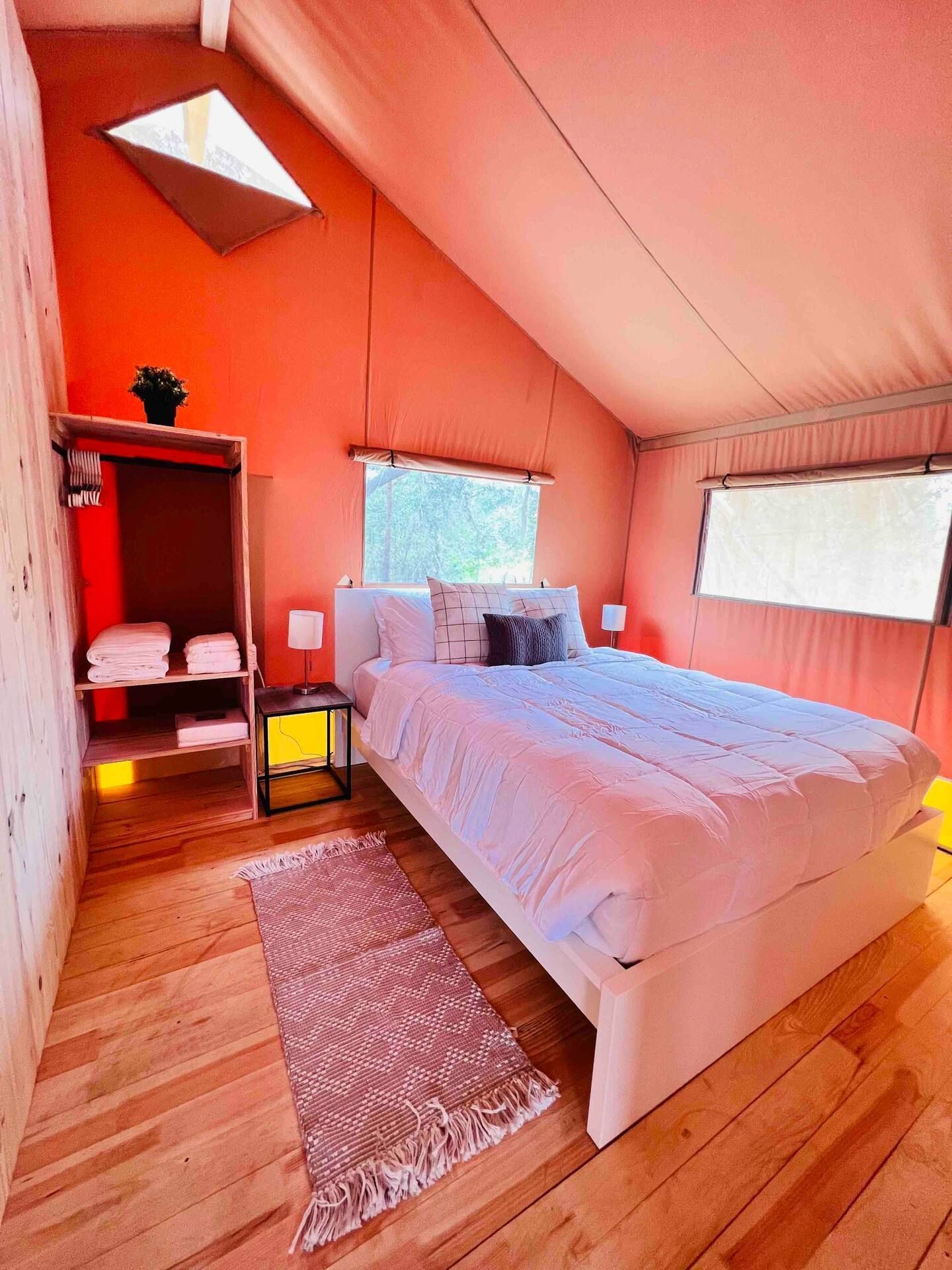 A bedroom with a large bed , a rug , and a window.