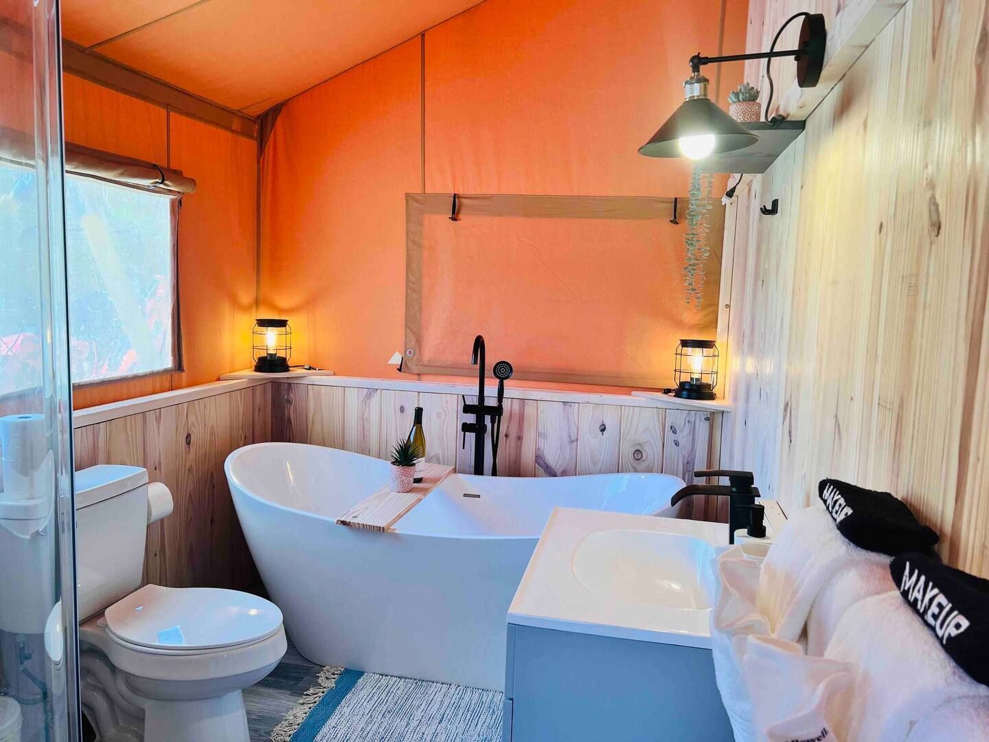 A bathroom with a tub , toilet , sink and shower.