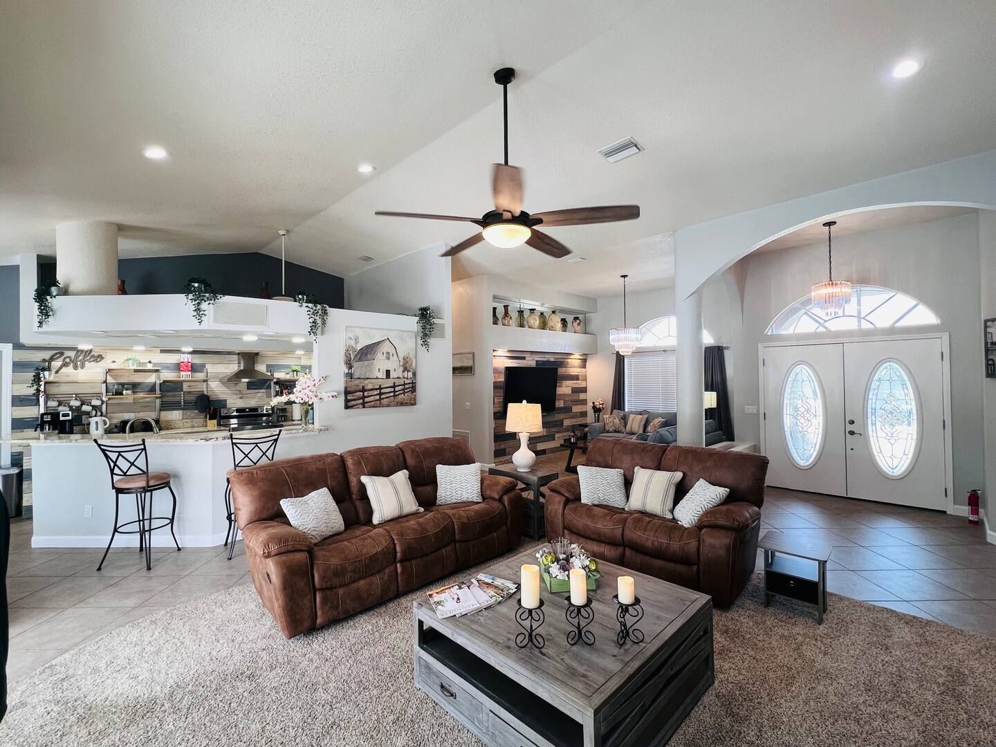 A living room with two couches , a coffee table , and a ceiling fan.