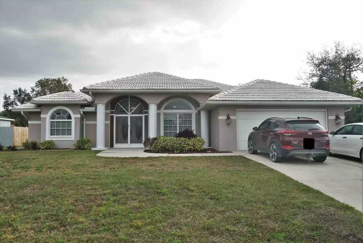 A house with a car parked in front of it.